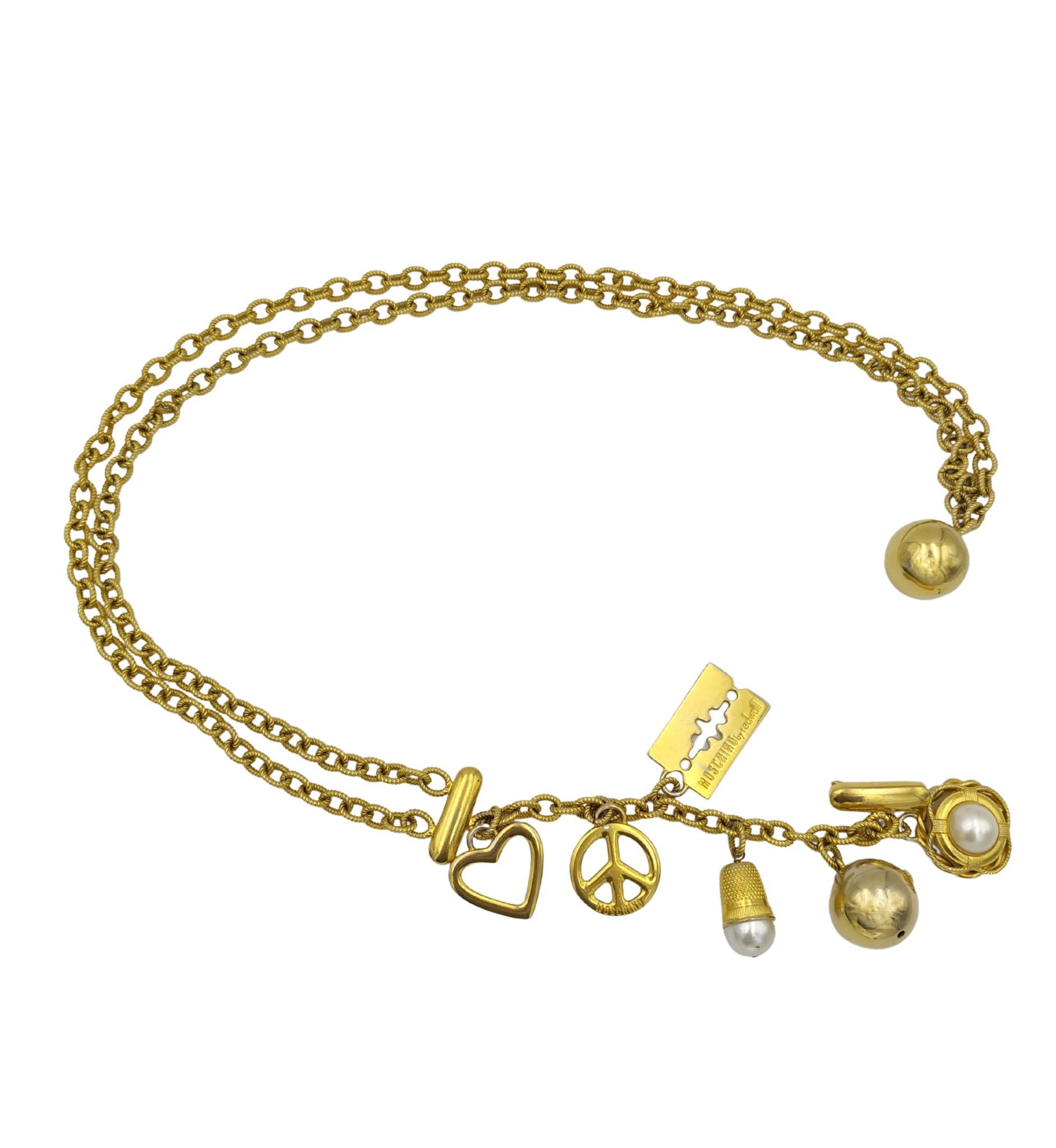 Cinturón de doble cadena con colgantes Moschino
Metal dorado y perlas de imitación

Medidas:
longitud máxima 85 cm 33,5 pulg.

Buen estado
Algunas marcas y roces
Algunos signos de envejecimiento y uso