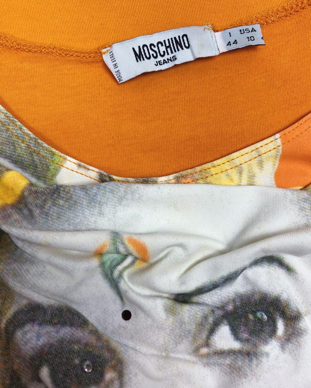 Entrez dans la mode italienne des années 90 avec ce t-shirt vintage Moschino, qui arbore un graphisme de divinité indienne rehaussé d'ornements en cristal noir.
Confectionnée en coton doux de haute qualité, cette chemise est à la fois confortable et