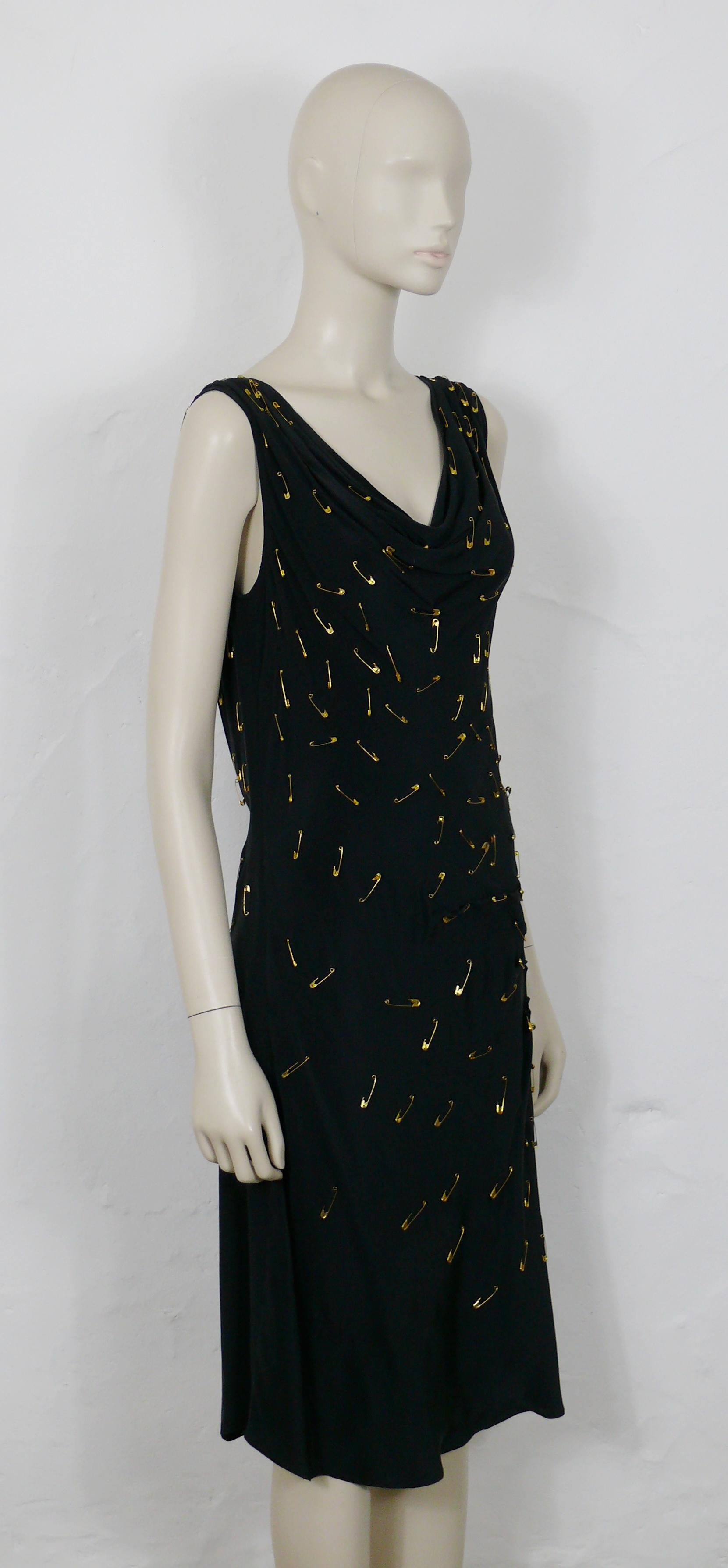 Robe noire embellie d'épingles à nourrice MOSCHINO, portée par KATE MOSS.

Fermeture à glissière cachée sur le côté.

Le label indique MOSCHINO CHEAP AND CHIC.

L'étiquette de la taille indique : I 48 / D 44 / F 44 / GB 16 / USA 14.
Veuillez vous