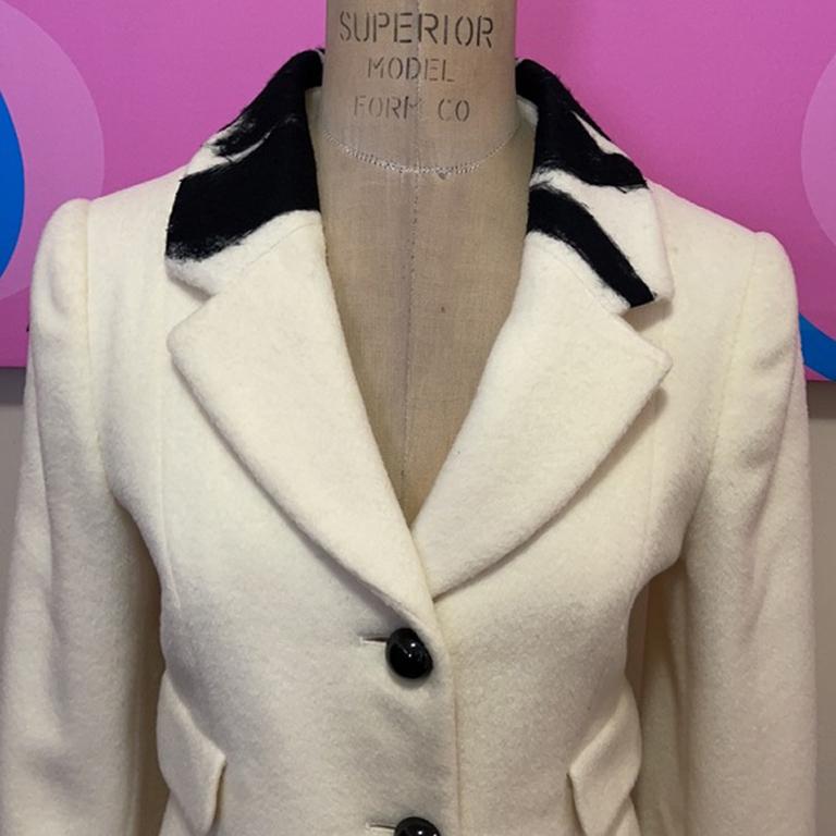 Moschino ivory black wool flower coat

Winder dressing is chic wearing this Moschino wool coat! Unique black floral design across the front and black plastic buttons. Pair with winter white for a great look. Brand runs small. 
Size 8

Across chest -