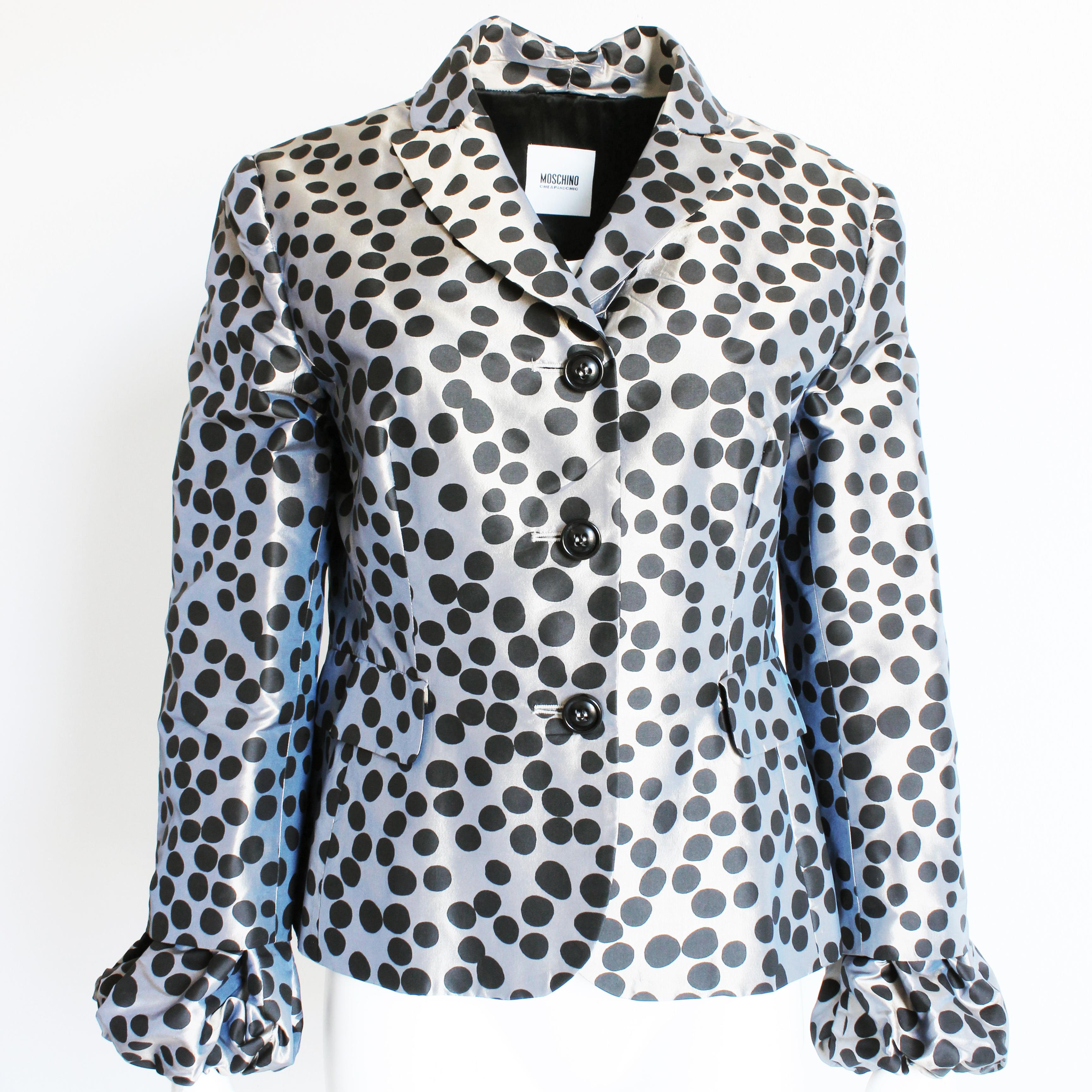 Authentic, preowned Moschino jacket, likely made in the late 2000s for their Cheap and Chic line.  Made from a gunmetal-silver silk fabric with black polka dots, it features elasticized puff sleeve cuffs and a flared hem.  

Fabulously chic and so