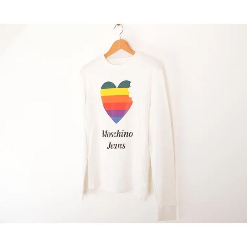Incredible Moschino Jeans 1990's long sleeve plain white T-shirt with vibrant Apple-Mac parody logo print. 

Features:
Rounded neckline
Long sleeves
Moschino Jeans front spell out
Plain Reverse

Made in Italy

100% Cotton

Sizing (in inches):
Pit to