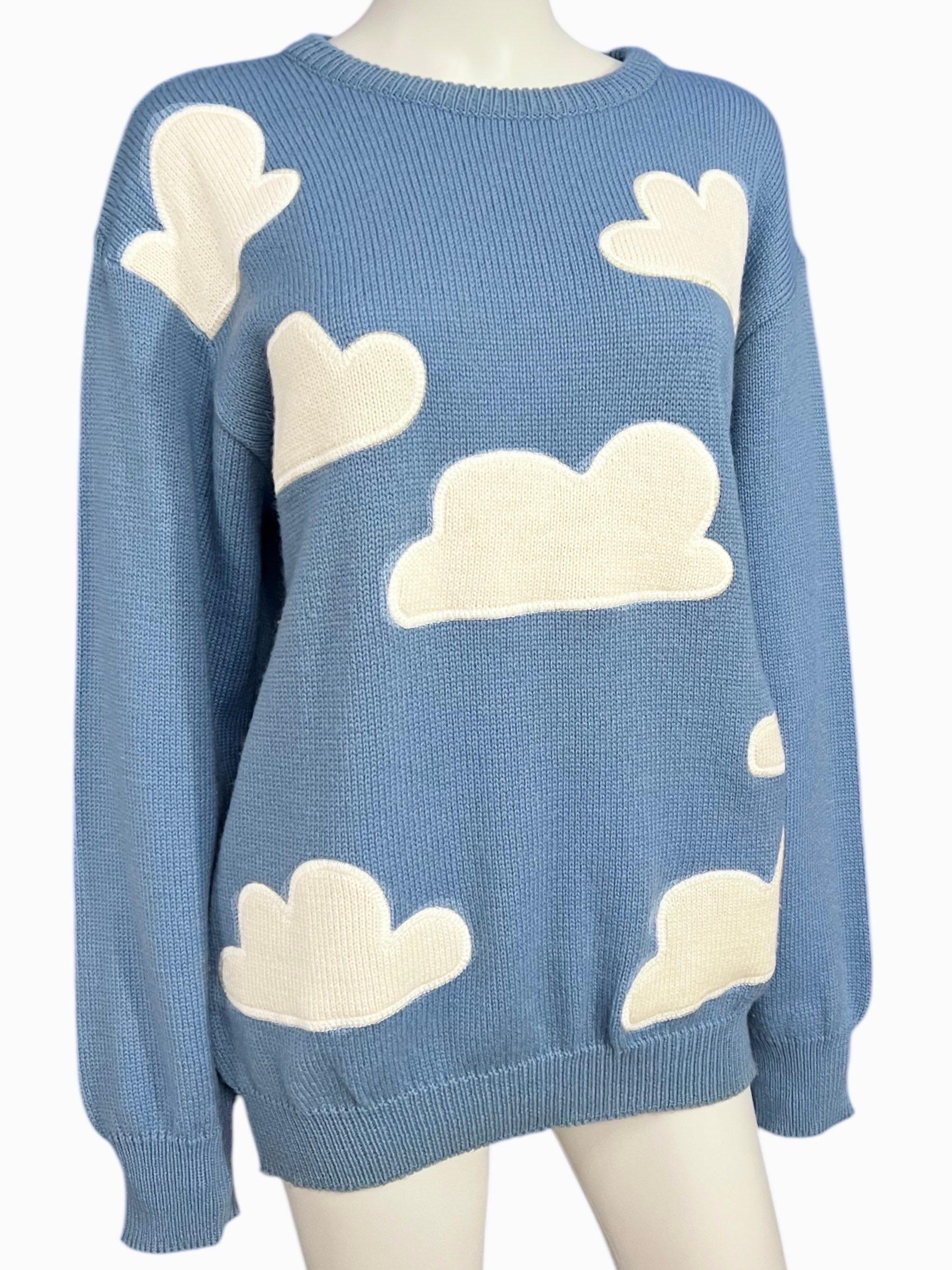 Maglione vintage a maglia all'uncinetto Moschino Jeans. Questo maglione stravagante presenta una vestibilità oversize con grandi applicazioni di nuvole bianche leggermente rialzate che conferiscono un giocoso effetto 3D.
Questo maglione cattura