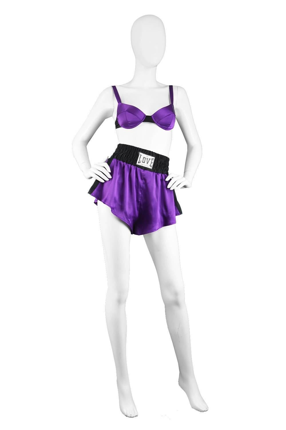 Moschino Lingerie Vintage 1990s Purple Satin Bra & Boxer Style Shorts Set

Estimated Size: UK 10/ US 6/ EU 38. Please check measurements. 
Bra Top
Bust - 32” / 81cm
Length (Shoulder to Hem) - 11” / 28cm

Shorts
Waist - Stretches from 24-28” /