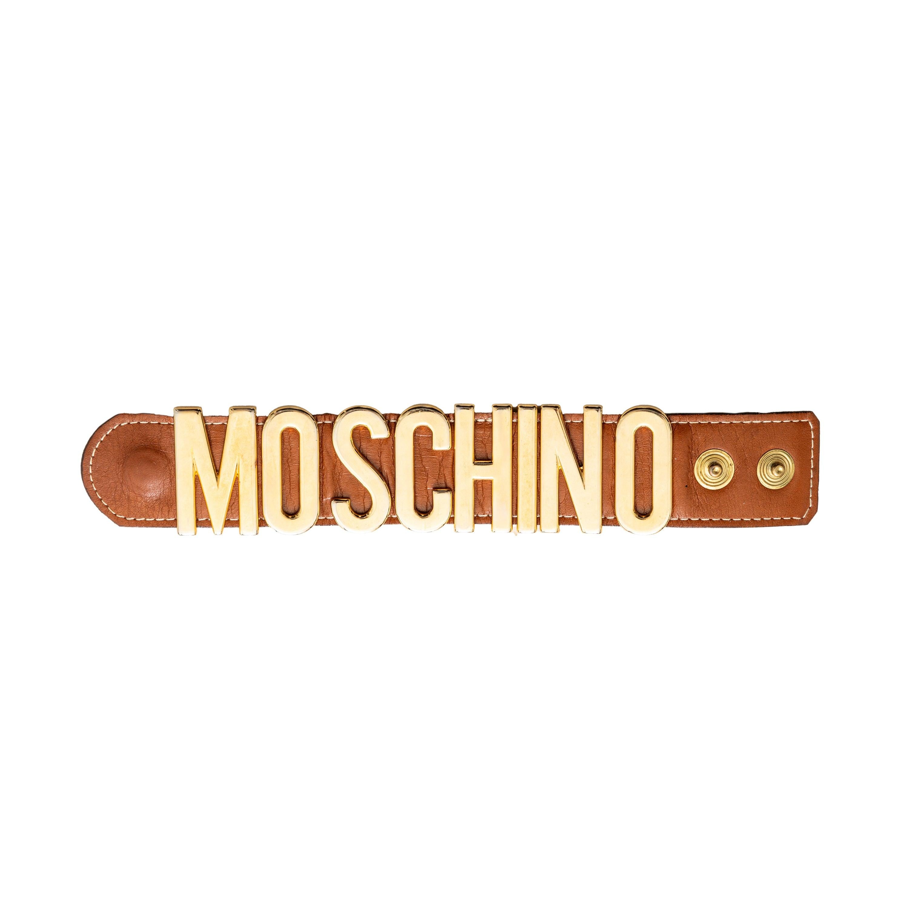 Upgrade your accessory game with the Moschino Logo Cuff Bracelet. Made with luxurious brown leather and adorned with gold tone brand name letters, this bracelet is the perfect statement piece. The two snap button closure adds convenience and