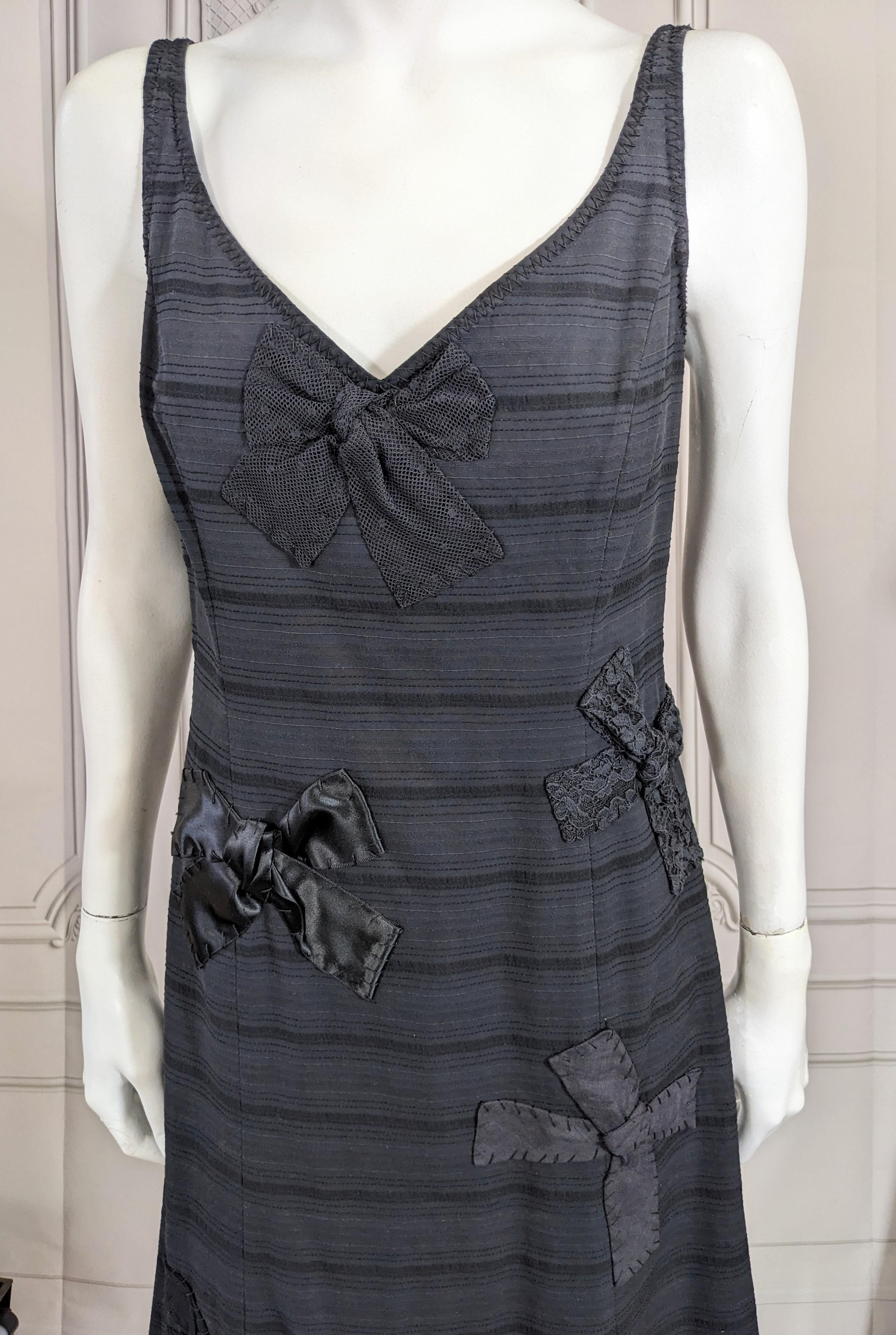 Moschino Baumwoll-Schleifenmotiv-Kleid mit einfachem, ausgestelltem Schnitt und Reißverschluss am Rücken. Schleifen aus verschiedenen Stoffen und Texturen sind auf den Körper des Kleides appliziert. Größe 8 USA. 1990er Jahre Italien. 