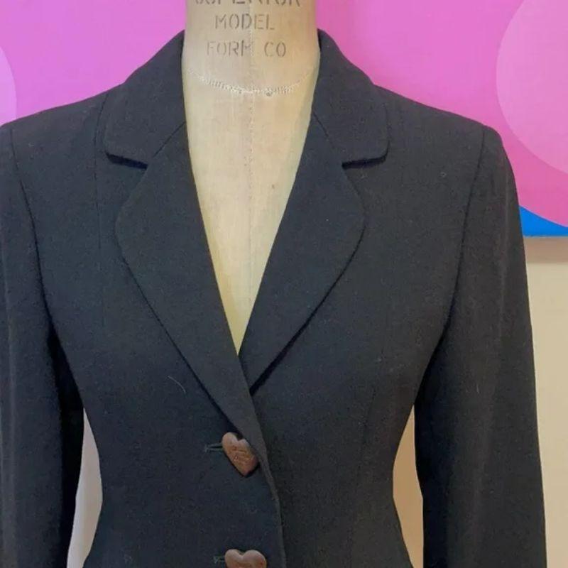 Moschino nature friendly garment black blazer

Franco Moschino' last line was the Nature Friendly Garment - this black wool blazer is from that collection. Has super cute wood buttons in the shape of a heart with a cute bow in the back. Pair with