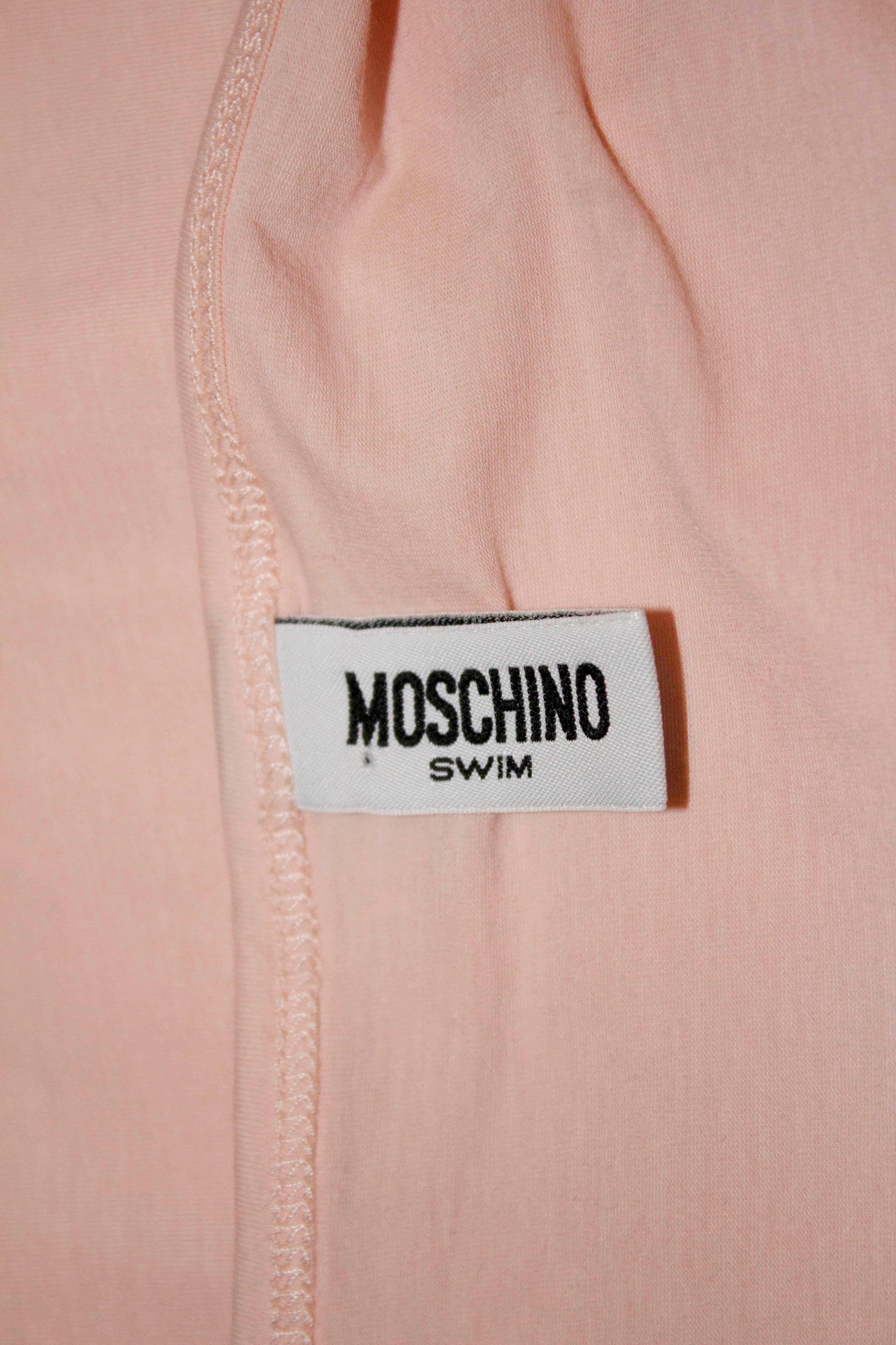 A pretty pink dress for the beach or holiday  by Moschino Swim. In a pretty shade of pink the dress has cap sleaves and a lace trim. 

Size Italian 42, bust 34'', length 33''.