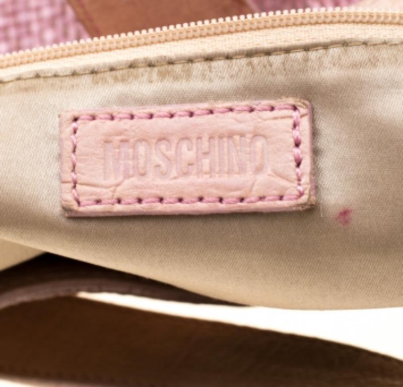 The Moschino hobo is crafted from jute and leather and features a front flap that is styled with gold-tone hardware. It flaunts a top handle and opens to a spacious suede-lined interior that houses a zip pocket.