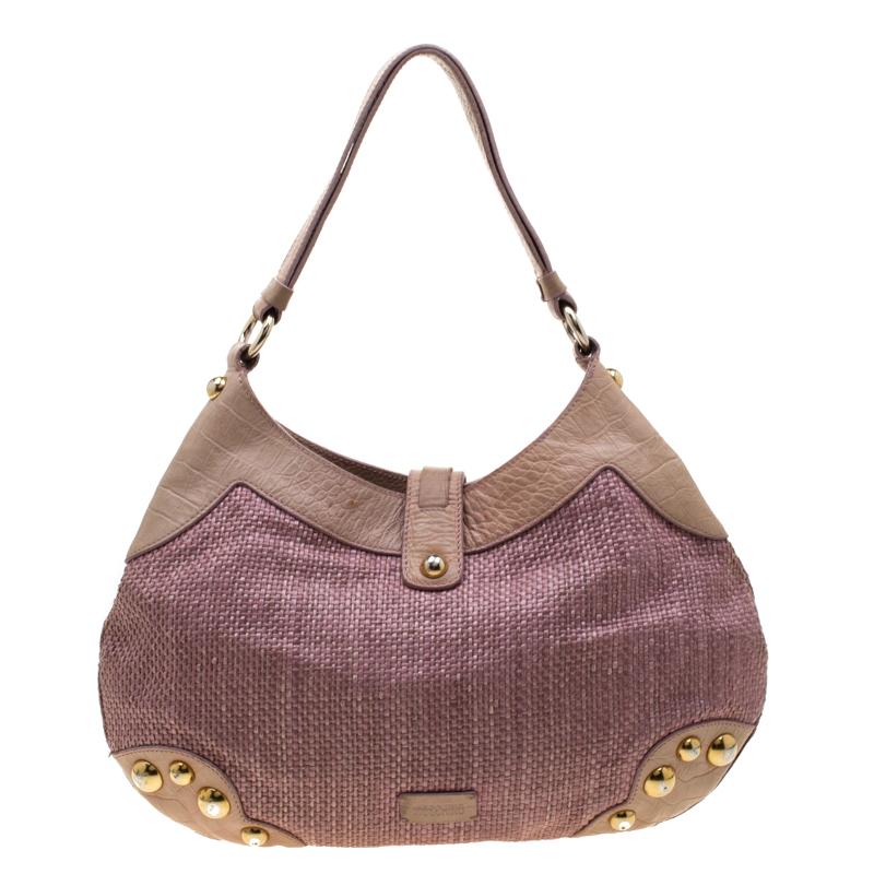 The Moschino hobo is crafted from jute and leather and features a front flap that is styled with gold-tone hardware. It flaunts a top handle and opens to a spacious suede-lined interior that houses a zip pocket.

