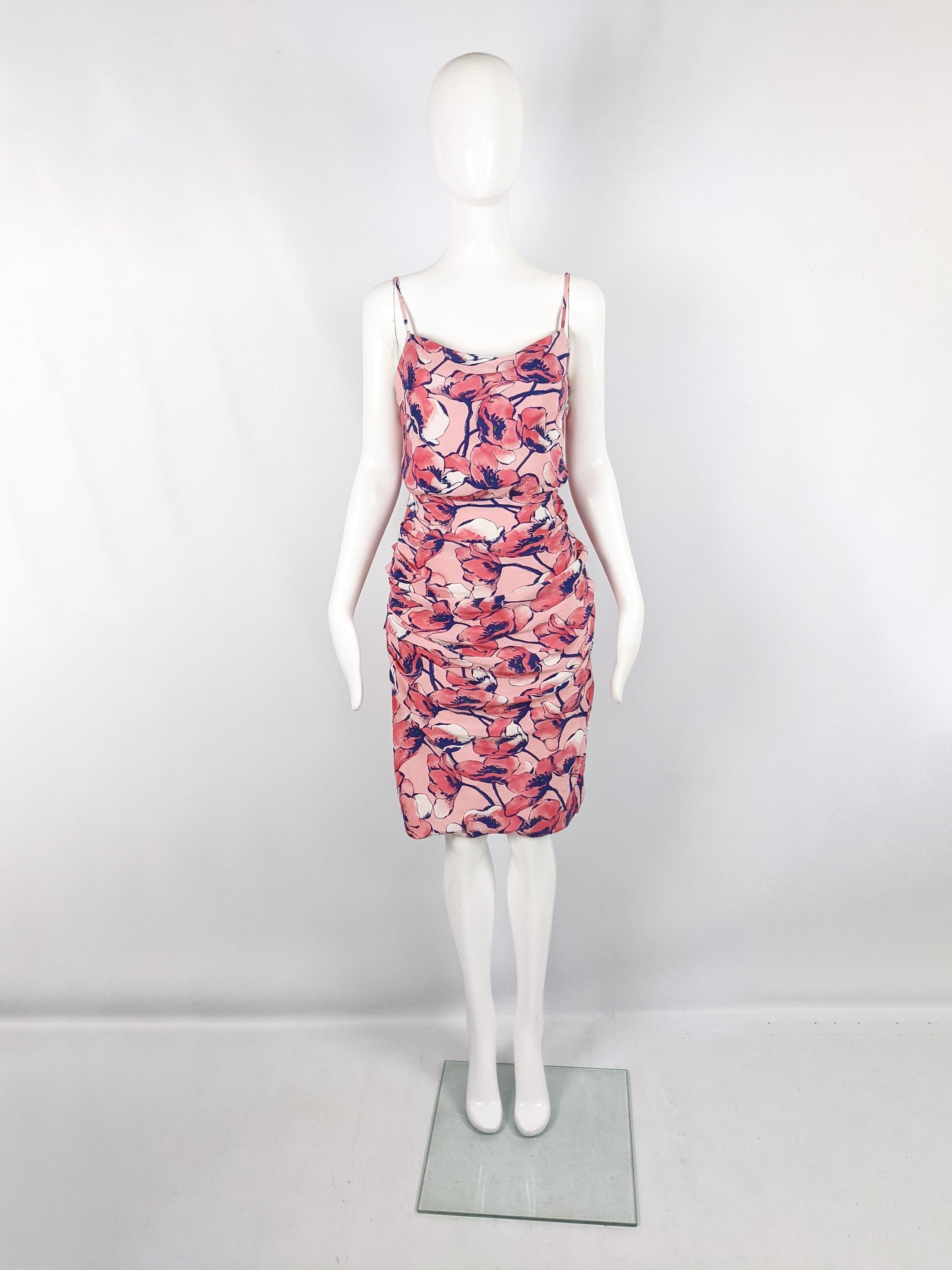 A stunning y2k vintage Moschino party dress from the late 90s / early 2000s. In a pink silk with a floral print throughout, a strappy, sleeveless design and a silhouette that is fitted and gathered on the skirt which is contrasted with a loose,
