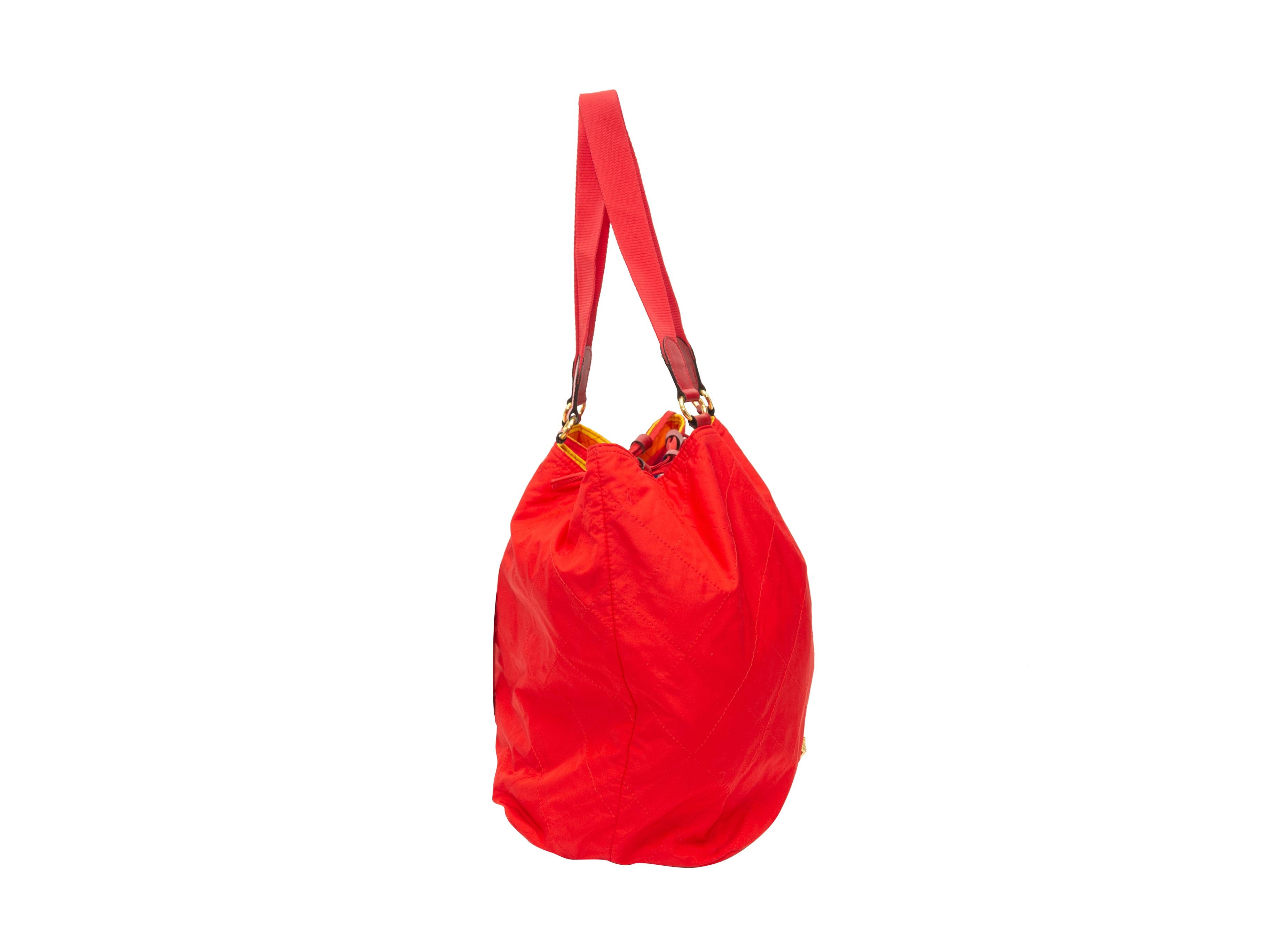 Product details: Vintage red and multicolor reversible nylon bag by Moschino. Gold-tone hardware. Dual shoulder straps. Drawstring closure at top. 17.5