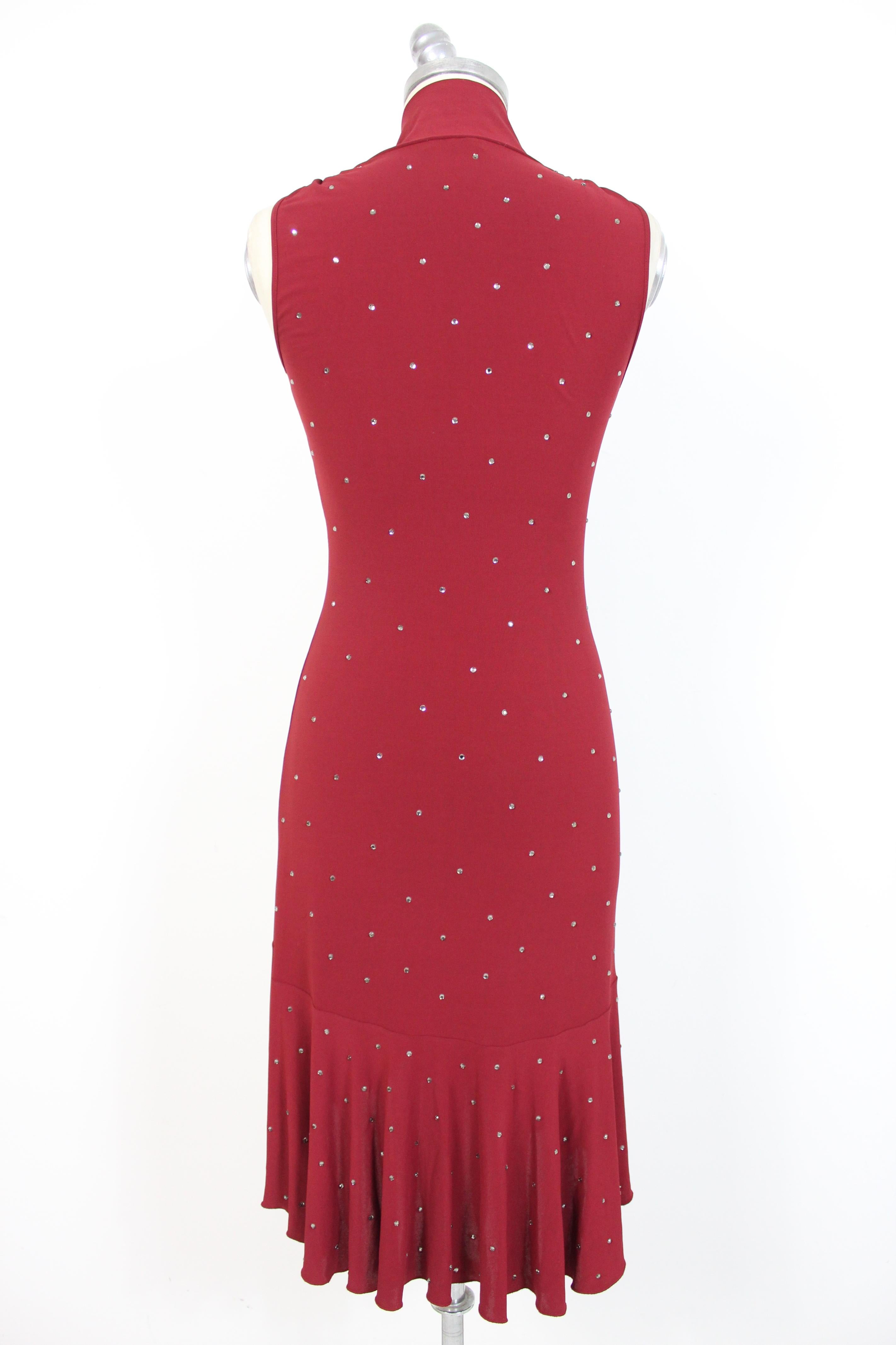 Moschino Cheap and Chic 90s vintage woman dress. Long dress, V-neckline with neck scarf. Flared skirt and longer on the back. Rhinestone applications. Burgundy color, fabric: 73% acetate, 18% polyamide, 9% elastane. Made in Italy. Excellent vintage