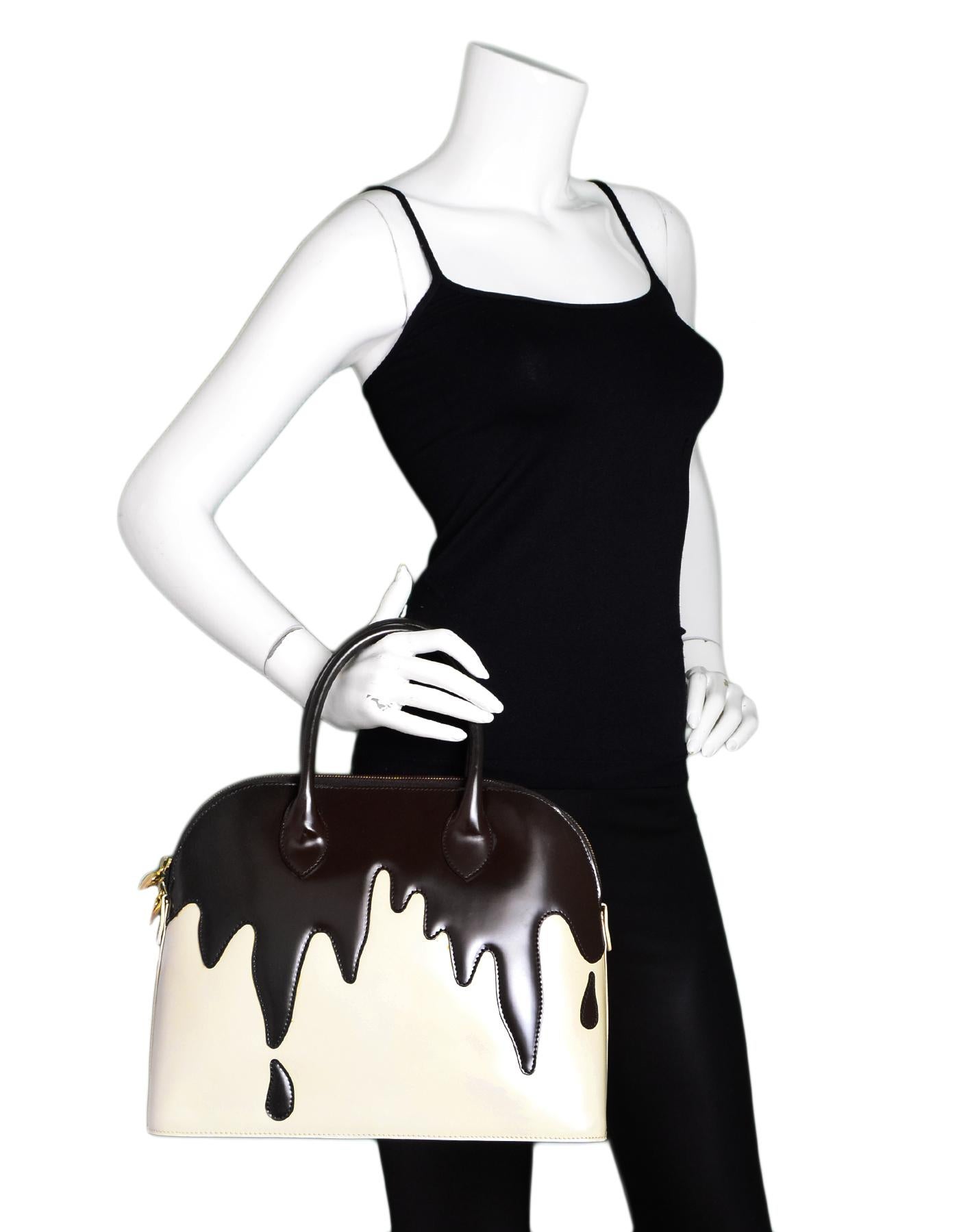 Moschino Brown/Cream Patent Leather Dripping Chocolate Bag W/ DB

Color: Brown/cream
Hardware: Goldtone
Materials: Patent leather, metal
Lining: Tan satin textile
Closure/Opening: Zip top
Exterior Pockets: None
Interior Pockets: One zippered wall
