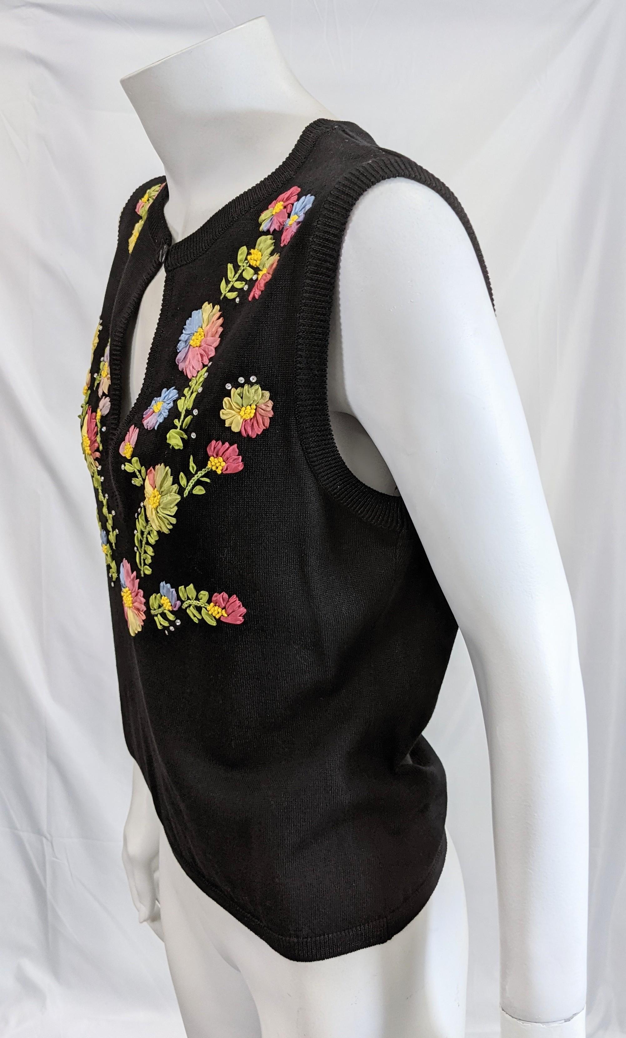 Moschino fine ribbon embroidery and crystal embellished black jersey knit sleeveless pullover. Of cotton and rayon with peek a boo front closure. Excellent Condition.
Length 21