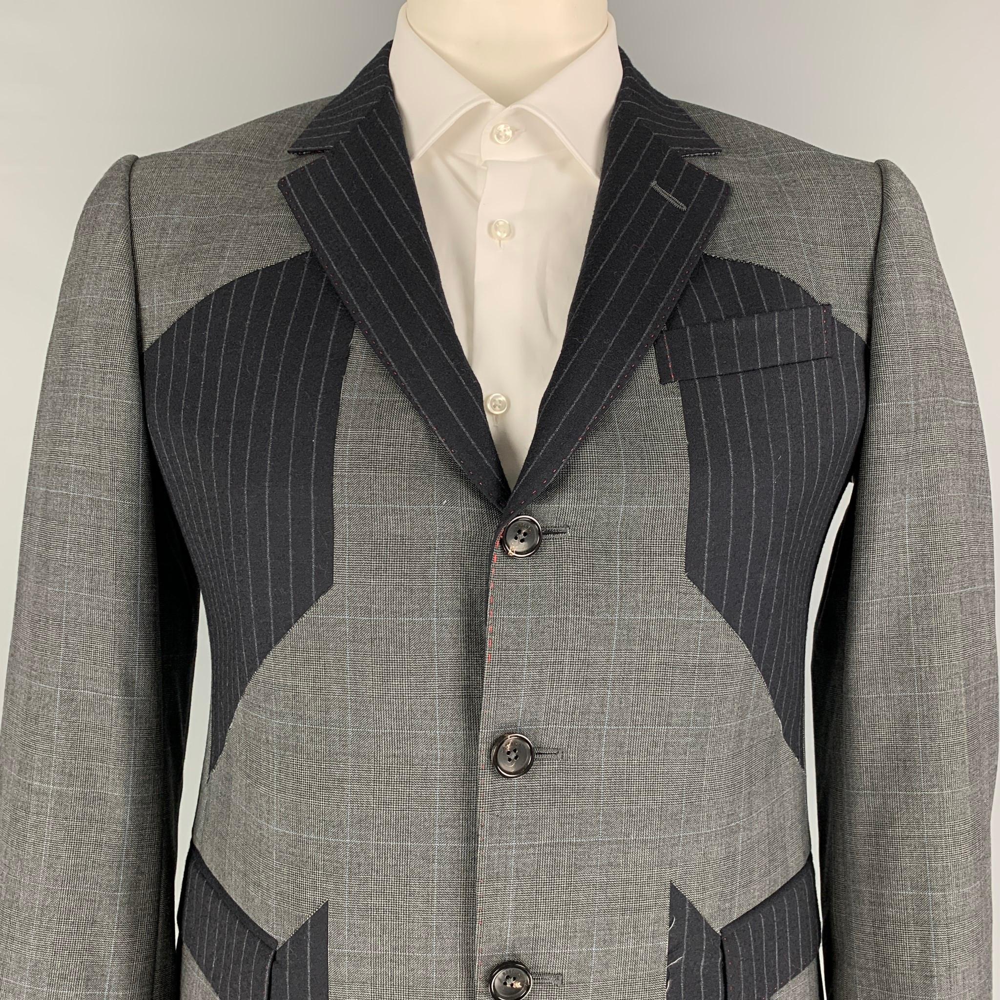 MOSCHINO sport coat comes in a grey & navy patchwork wool with a full liner featuring a notch lapel, flap pockets, double back vent, and a three button closure. Made in Italy. 

Excellent Pre-Owned Condition.
Marked: 52

Measurements:

Shoulder: 18