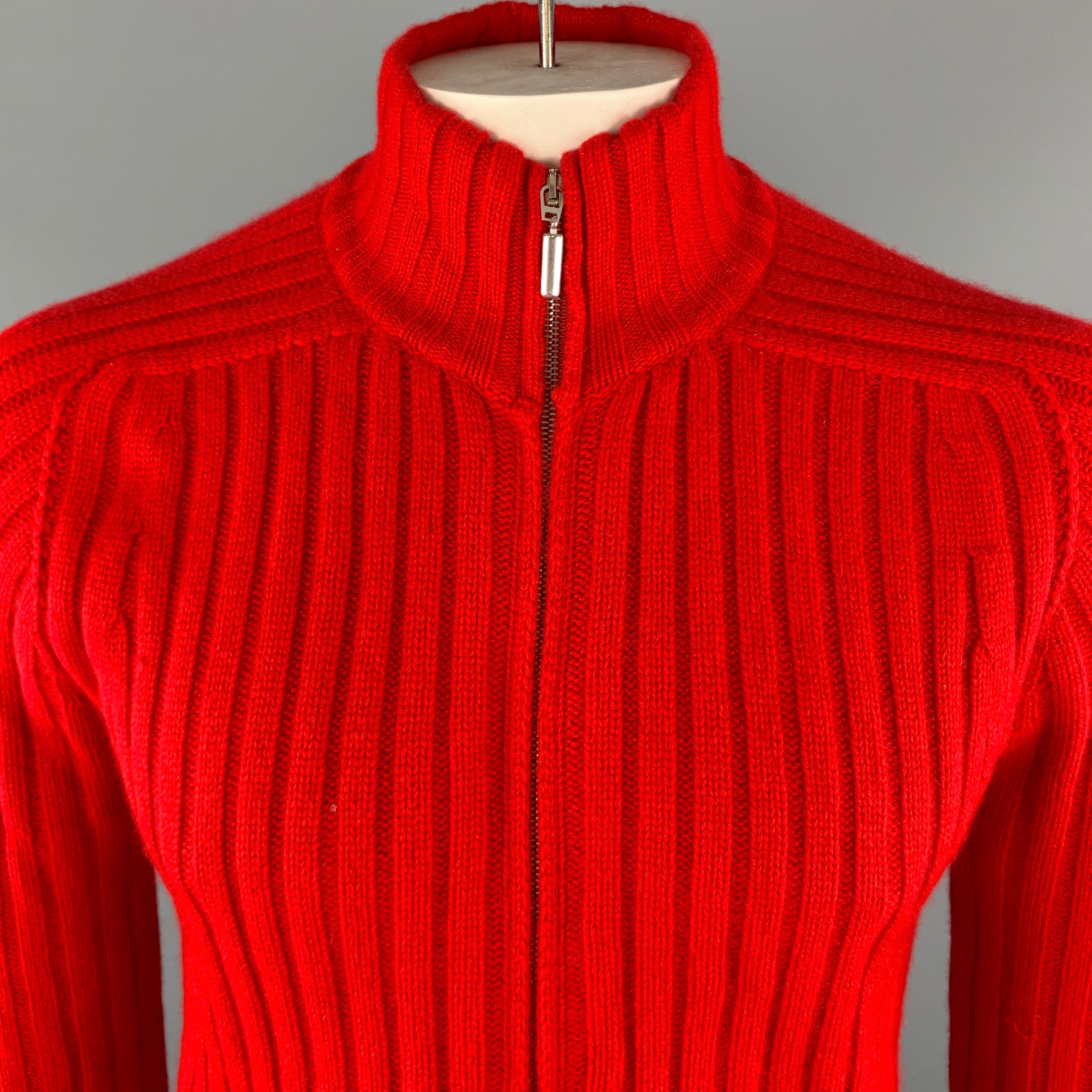 MOSCHINO Pullover Sweater comes in a brilliant red tone in a ribbed cashmere material, with a high collar, slit pockets, zip up. Made in Italy.

Excellent Pre-Owned Condition.
Marked: IT 54

Measurements:

Shoulder: 18 in. 
Chest: 43 in. 
Sleeve: 27