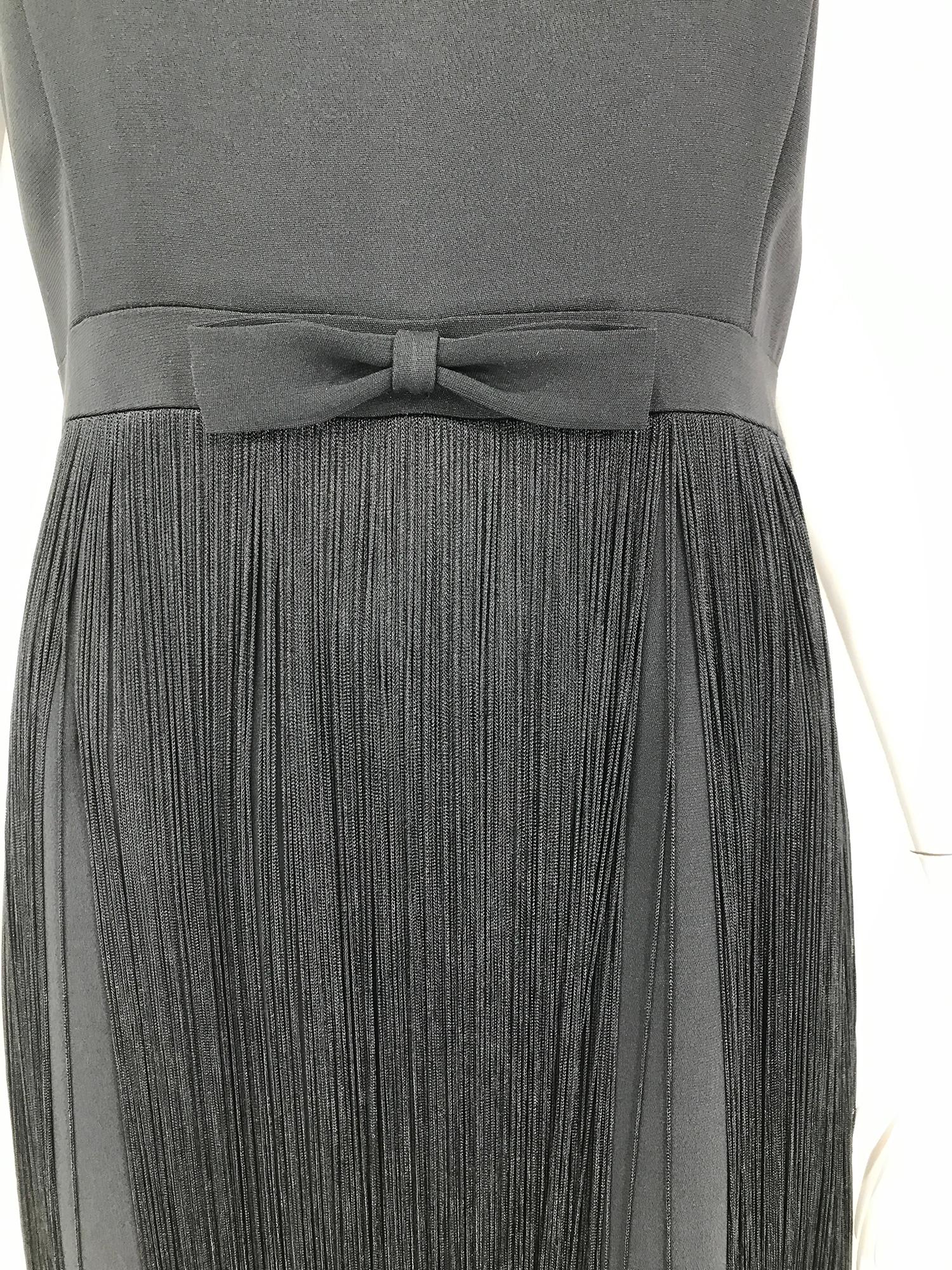 Moschino ärmelloses Kleid aus schwarzem Krepp mit Schleife an der Taille und Fransen aus den 1990er Jahren. Schmuckhals, ärmelloses Kleid mit abgeschrägtem Mieder und abgeschrägtem Mieder. Band-Taille mit einer abgeschrägten Schleife an der Taille