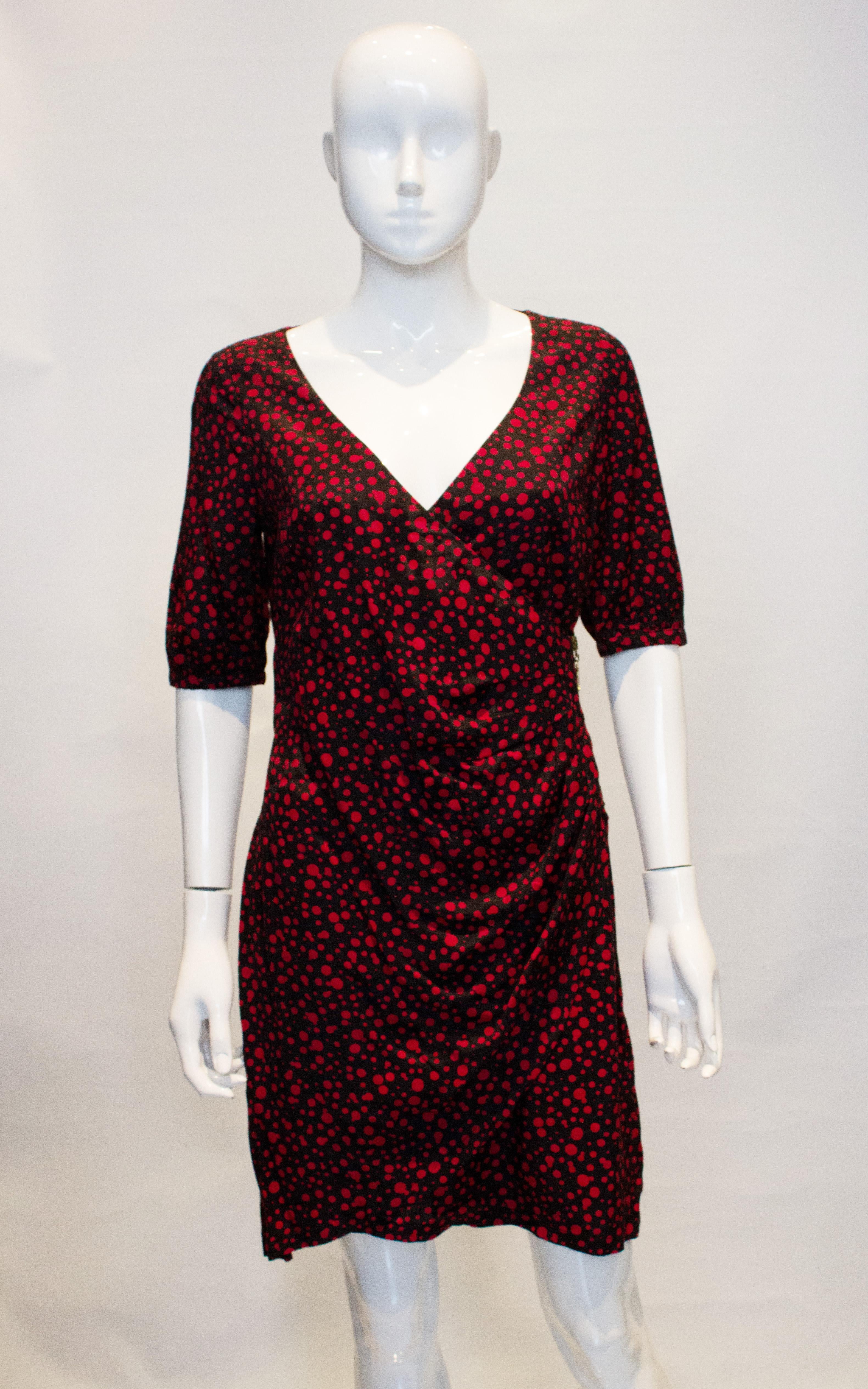 A wonderful Moschino dress , black with crimson spots. The dress has a wrap over front with zip detail, side zip opening and is fully lined. 