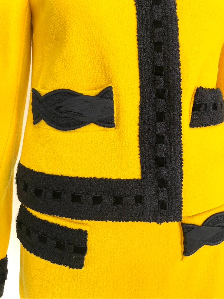 Bright yellow wool with asymmetrical black trim on jacket and skirt. Concealed closure. Mini skirt