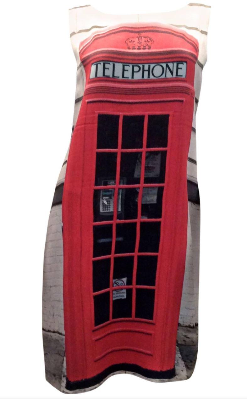 Presented here is a beautiful sleeveless dress from Moschino. The front is adorned with an image of a British telephone booth. The back of the dress is a solid black. The silk-like fabric is a combination of 78% acetate and 22% rayon. This fun dress