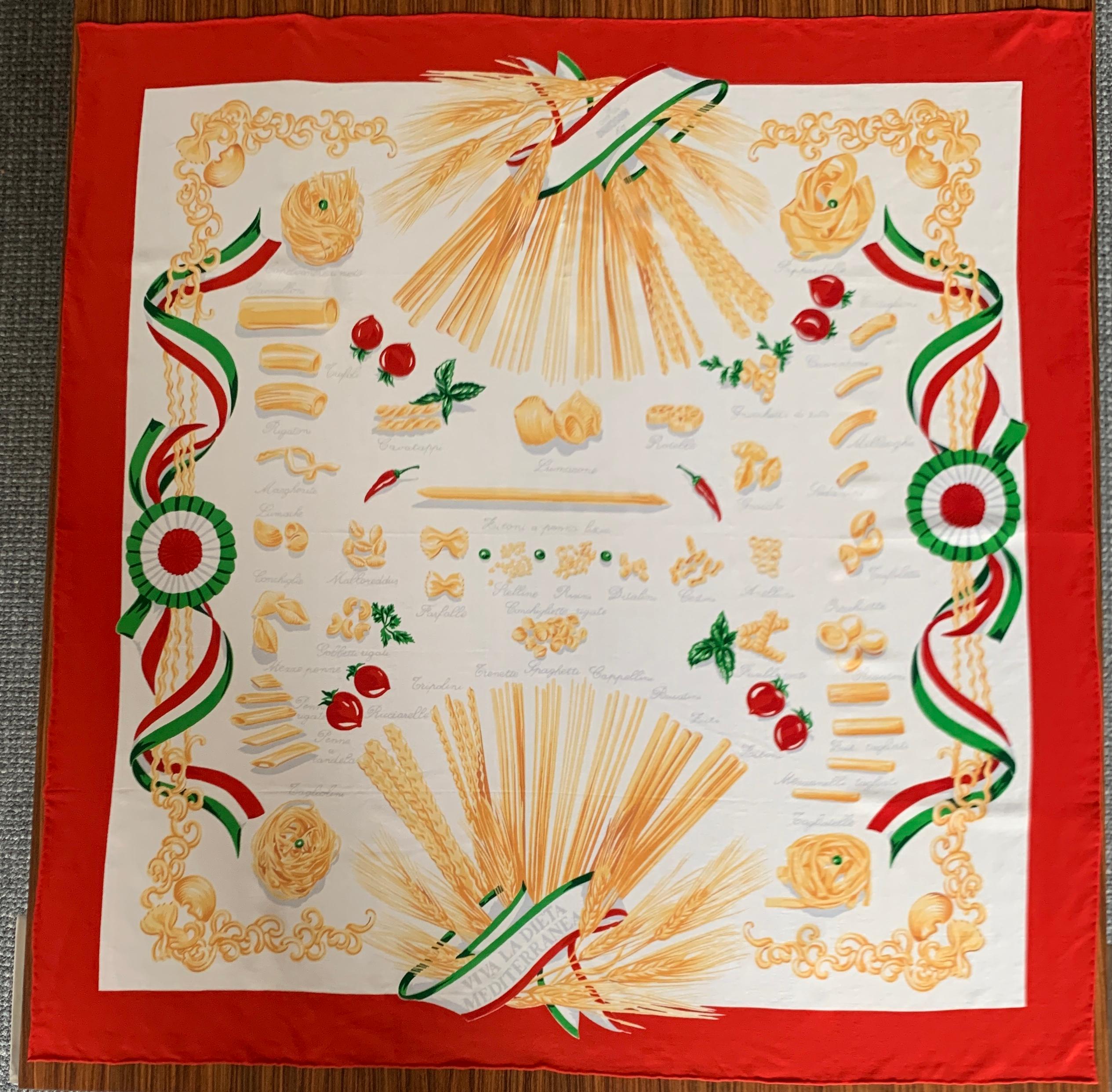 Moschino 90s white Italian pasta print scarf features an illustrated directory of all kinds of pasta. Tagliatelle, bucatini, farfalle, rigatoni-- it has it all! Red, white, and green ribbon illustration at sides. Hand rolled edges.

Fabric tag