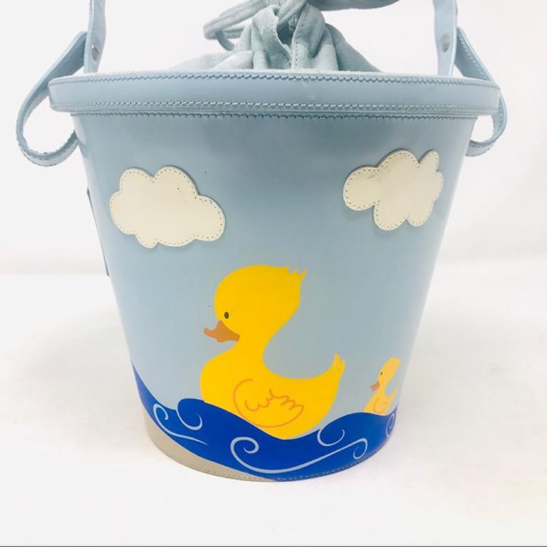Moschino vintage blue sand pail duck bag

This vintage Moschino Sand Pail Duck and Umbrella bag is super cute! Museum quality! Leather. Suede lining and suede draw string top.

Around Bag at top - 26 inches
Top to bottom - 7 inches
Strap Drop - 9