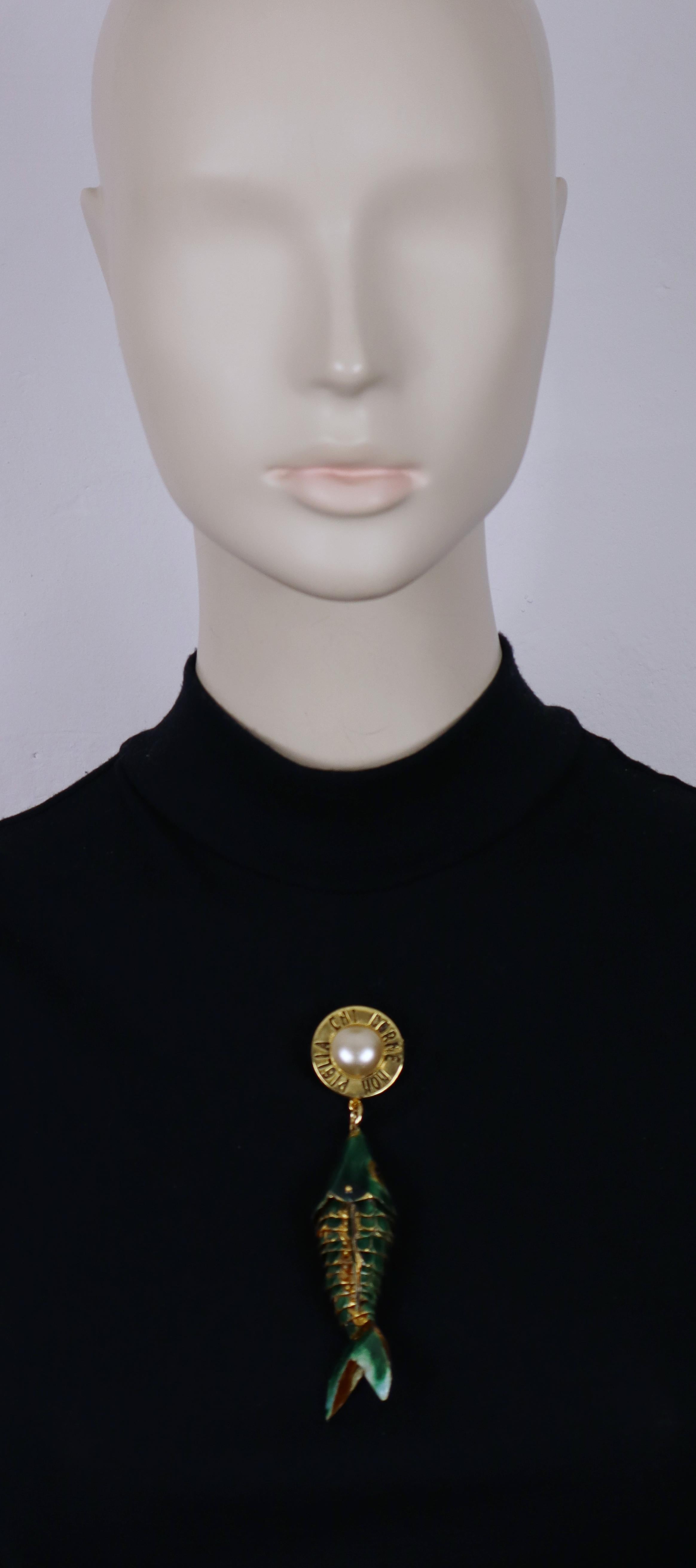 MOSCHINO vintage gold tone brooch featuring an enameled and articulated fish topped by a faux pearl and the quote 