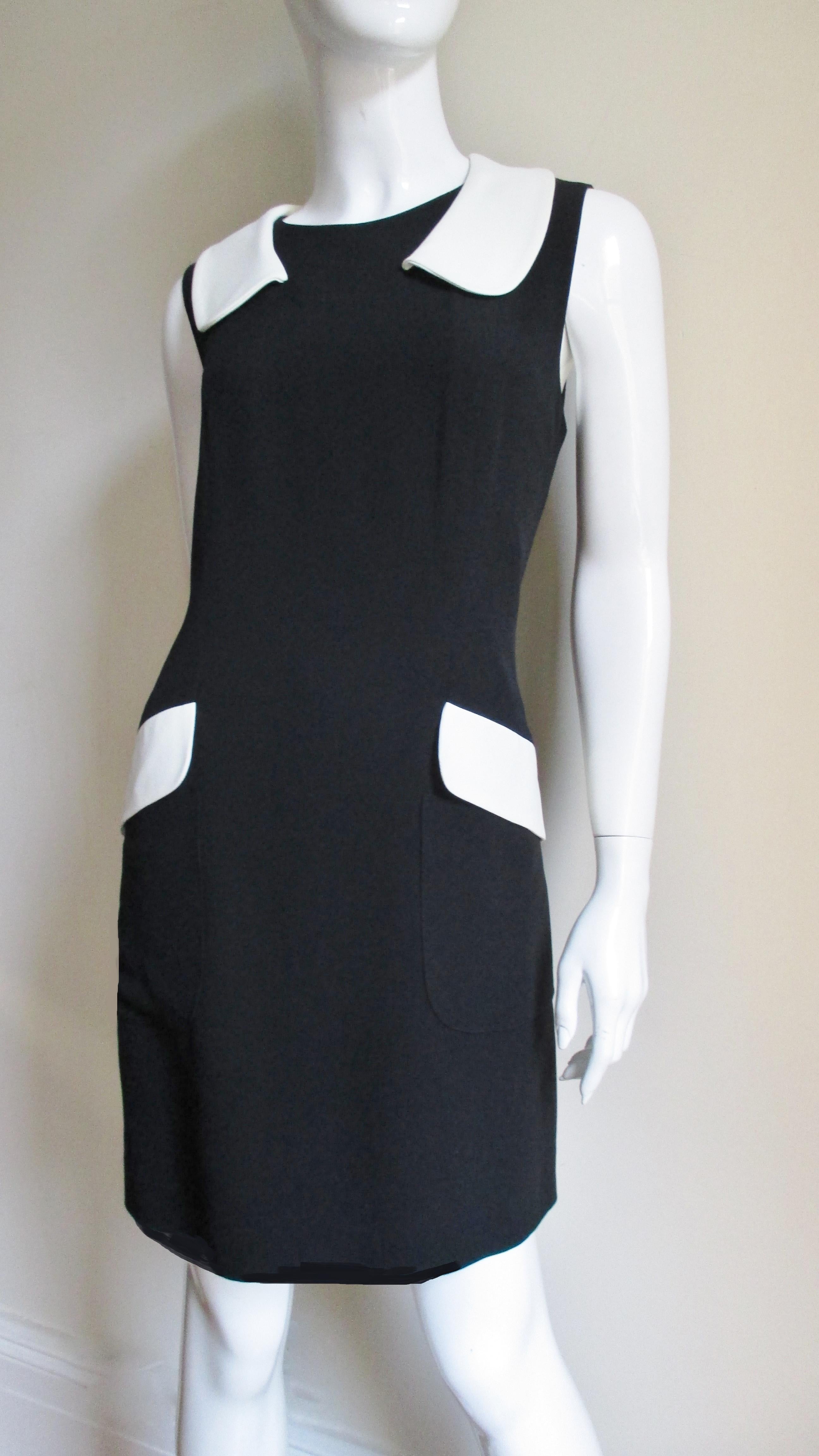 A great black and off white dress from Moschino. The sleeveless semi fitted dress has an off white peter pan collar and large front patch pockets with off white flaps. It is fully lined and has a back zipper.
Fits size Medium. Marked Italian size