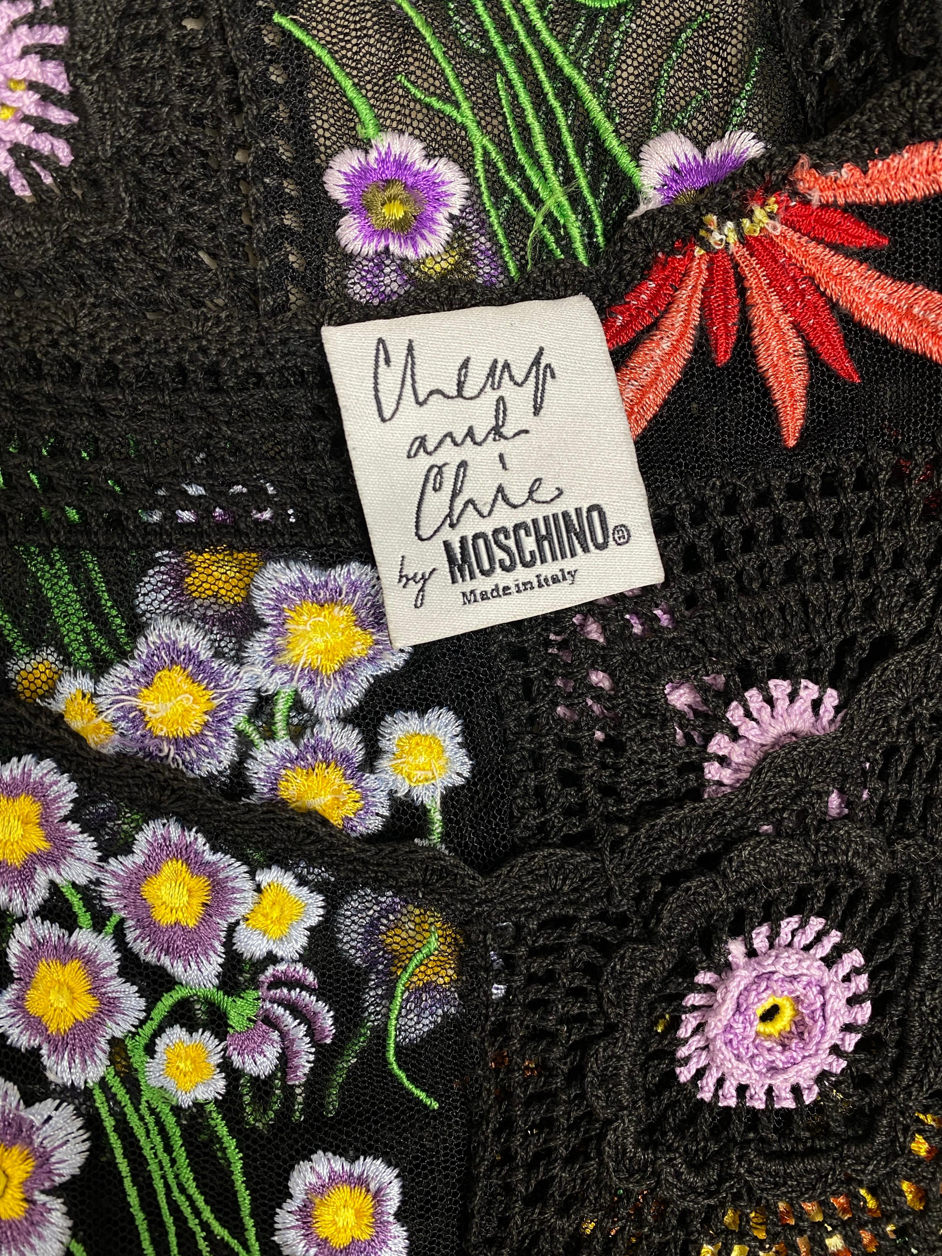 Entdecken Sie zeitlose Eleganz mit diesem schwarzen Midikleid aus Häkelstrick von Moschino aus den 1990er Jahren. 
Mit seiner aufwendigen floralen Netzstickerei ist dieses Modell ein Beispiel für Moschinos unverwechselbare Mischung aus Raffinesse