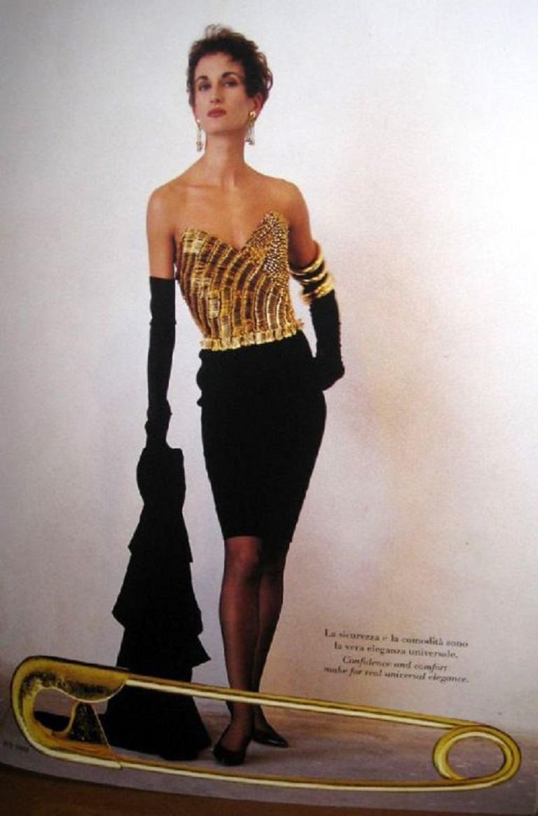 MOSCHINO vintage rare and iconic black cotton blend bustier dress embellished with bronze tone safety pins.

Back zippered closure.
Lining only all around the bust.

Label reads MOSCHINO Milano.

Size tag reads : I 44 / F 42 / D 40 / GB 14 / USA