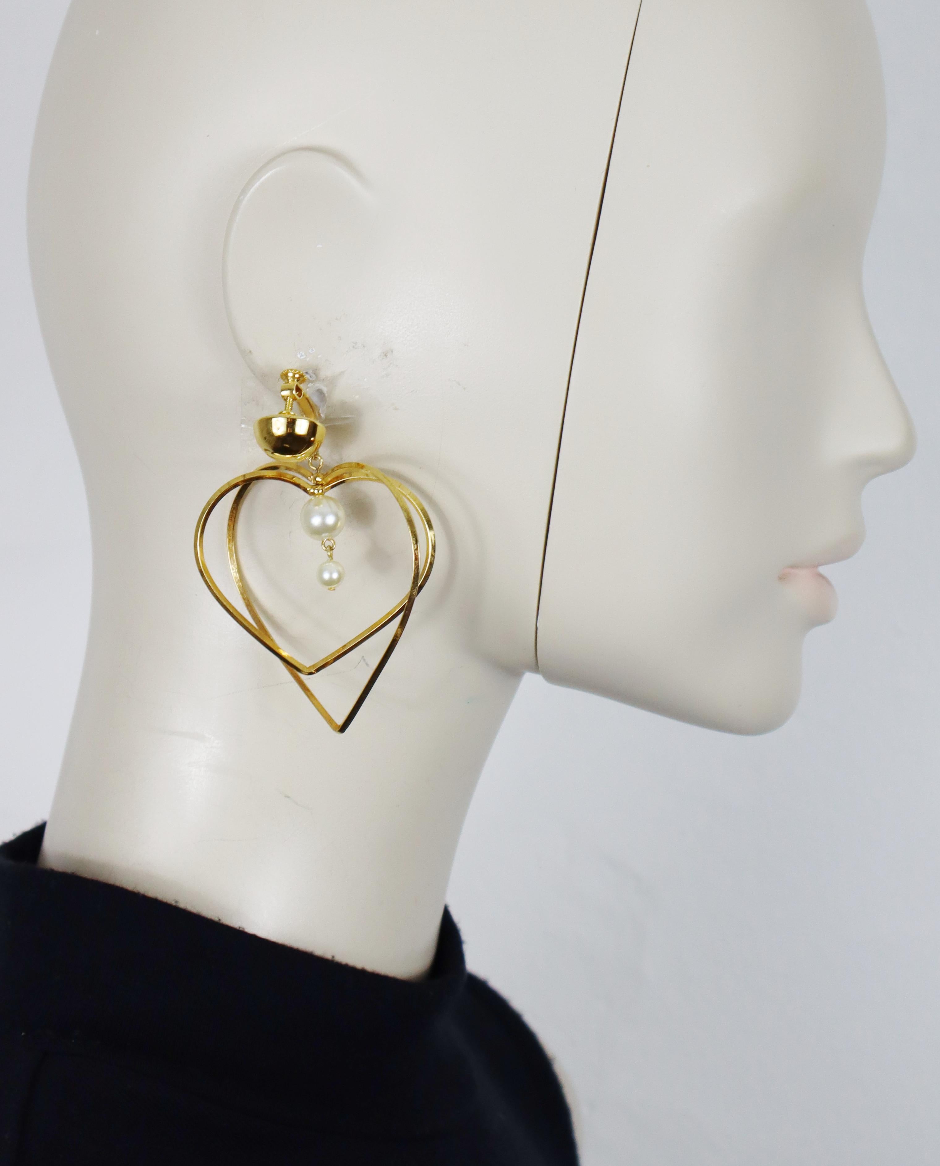MOSCHINO vintage gold tone heart dangle earrings (clip-on with screw system) embellished with two faux pearls.

Embossed MOSCHINO (only on one earring).

Indicative measurements : height approx. 7.3 cm (2.87 inches) / max width approx. 5.7 cm (2.24