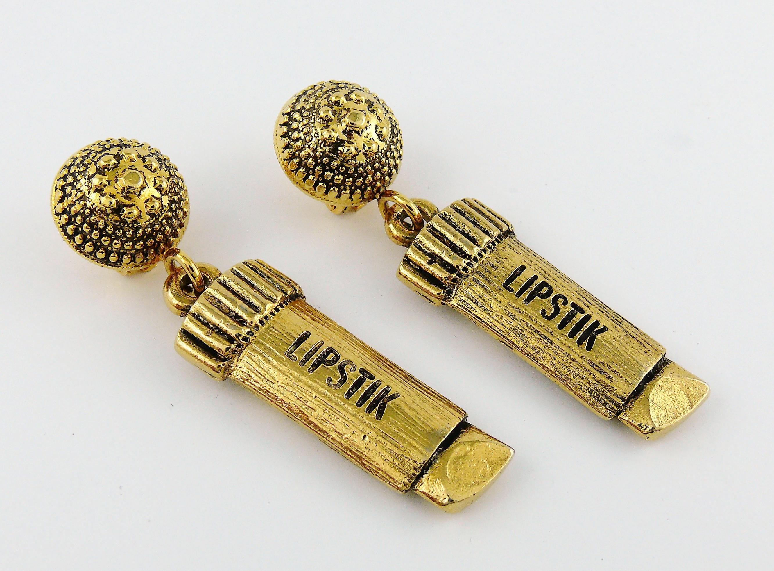 MOSCHINO vintage antiqued gold toned dangling earrings (clip-on) featuring a lipstick tube.

Embossed MOSCHINO.

Indicative measurements : height approx. 6.5 cm (2.56 inches) / max. width approx. 1.6 cm (0.63 inch).

Comes with original box (used
