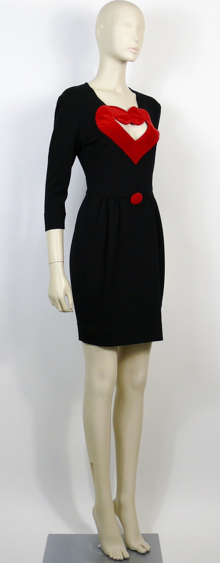 MOSCHINO vintage black dress featuring a large cut-out red velvet heart shaped breast.

This dress features :
- Black wool blend fabric.
- Large cut-out red velvet heart shaped breast with matching oversized button.
- Hidden back zipper closure.
-