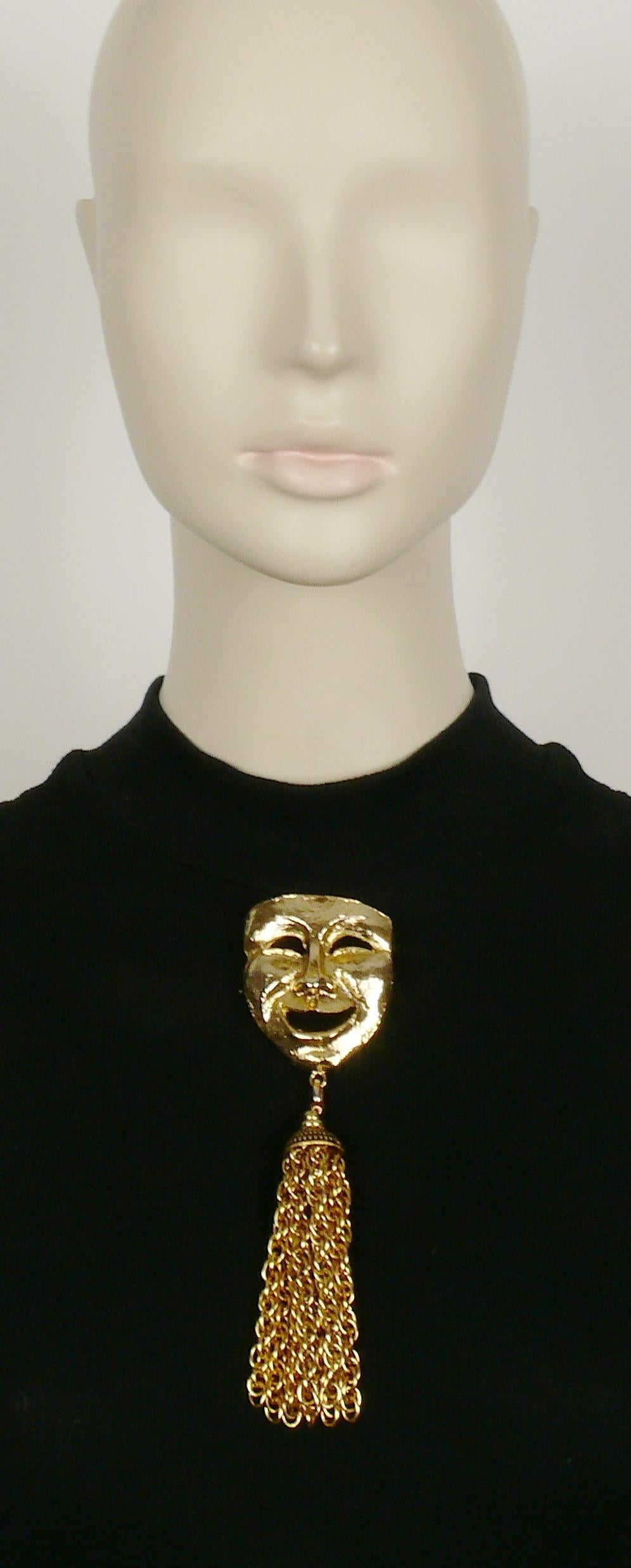 MOSCHINO vintage massive gold toned comedy mask brooch featuring a long chain tassel.

Embossed MOSCHINO.

Has weight on it.

Indicative measurements : height approx. 16 cm (6.30 inches) / max. width approx. 4.5 cm (1.77 inches).

NOTES
- This is a