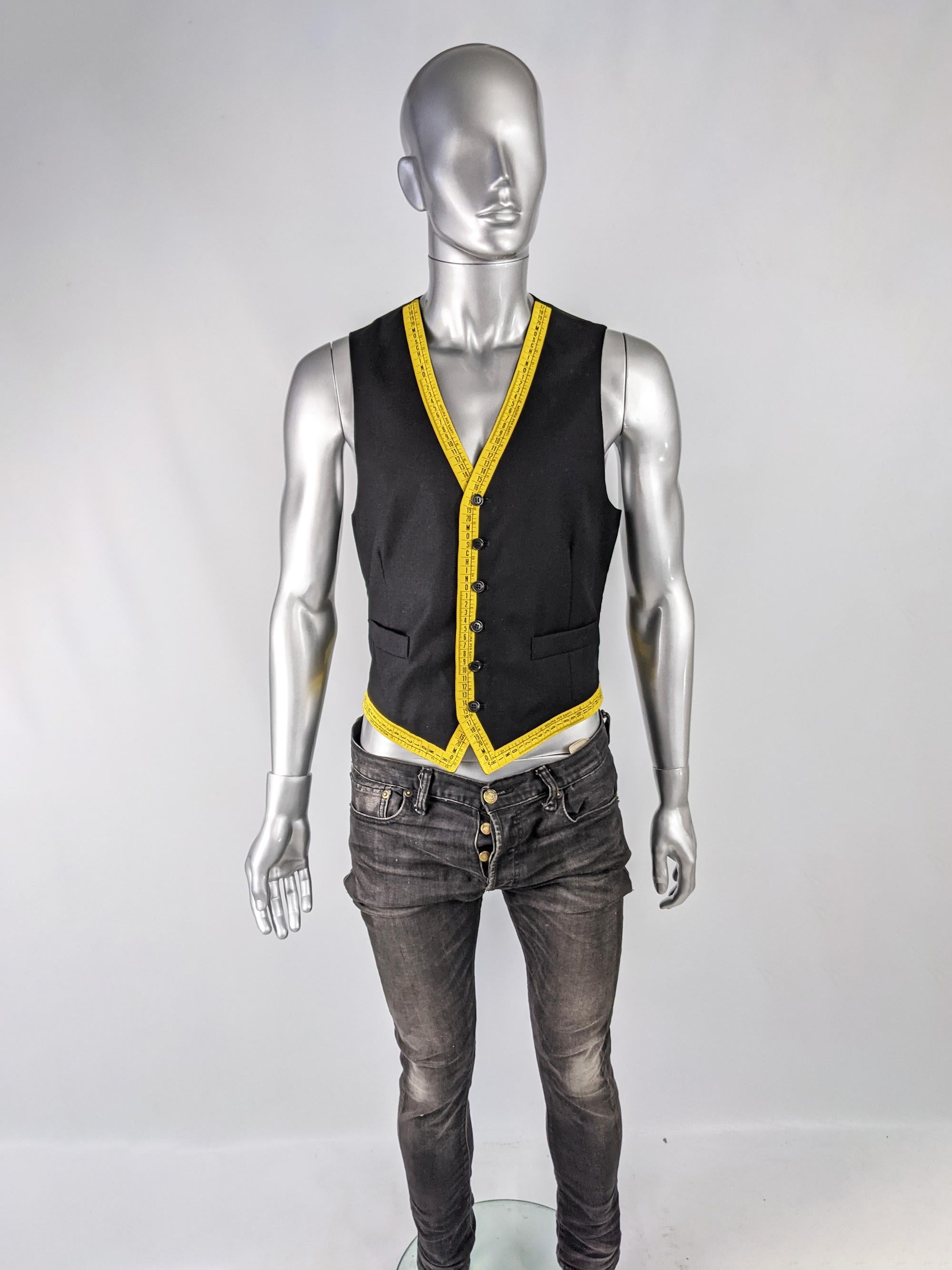 A rare and iconic vintage mens Moschino waistcoat from the late 80s / early 90s. Made in Italy, from a black wool with a cool tape measure design with Moschino spellouts in places.  

Size: Marked IT 48 / GB 38 / US 38 which roughly translates as a