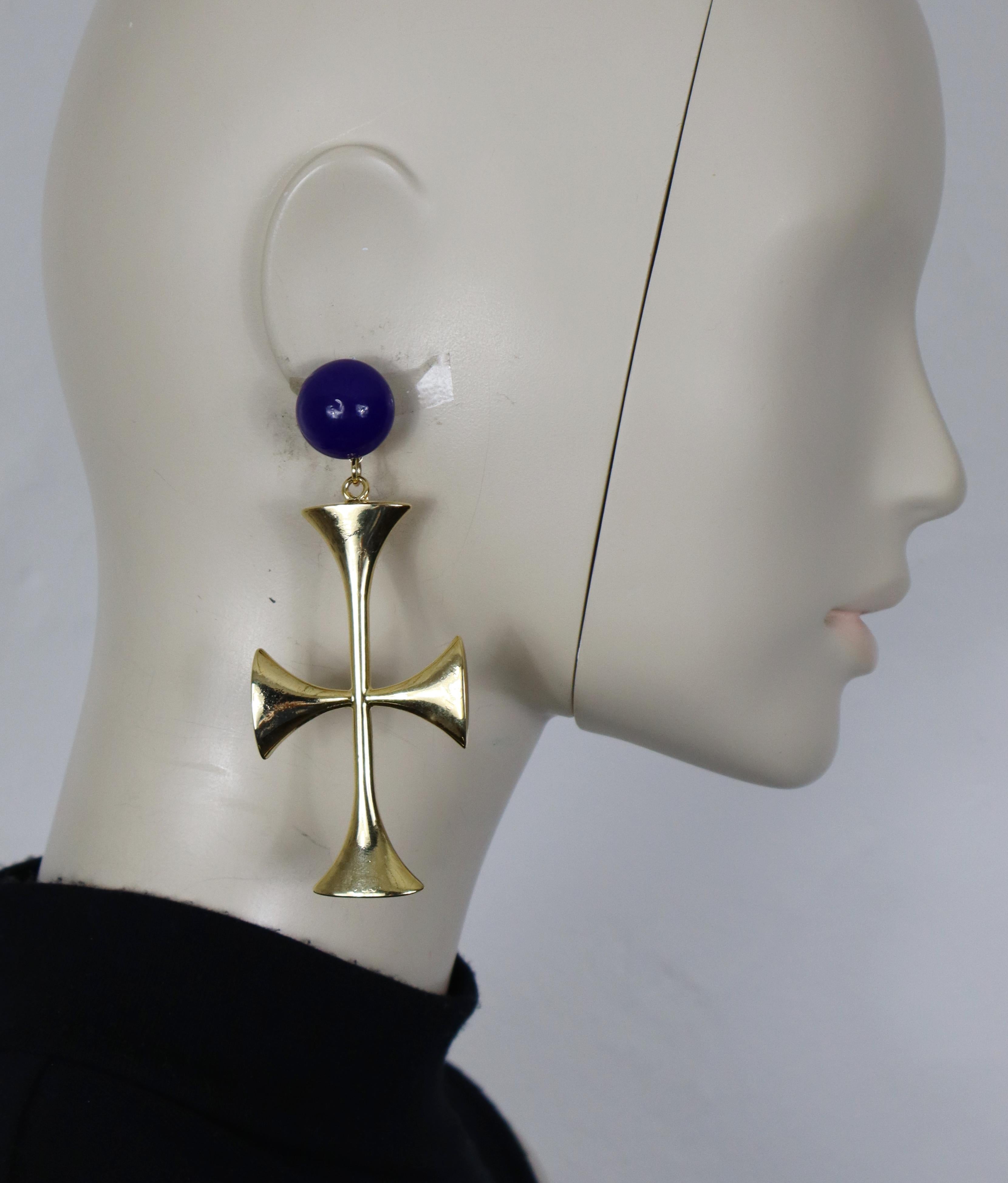 MOSCHINO vintage oversized gold tone cross dangling earrings (clip-on) topped by a domed blue glass cabochon.

Embossed MOSCHINO.

Indicative measurements : height approx. 10.5 cm (4.13 inches) / max width approx. 4.3 cm (1.69 inches).

Weight per
