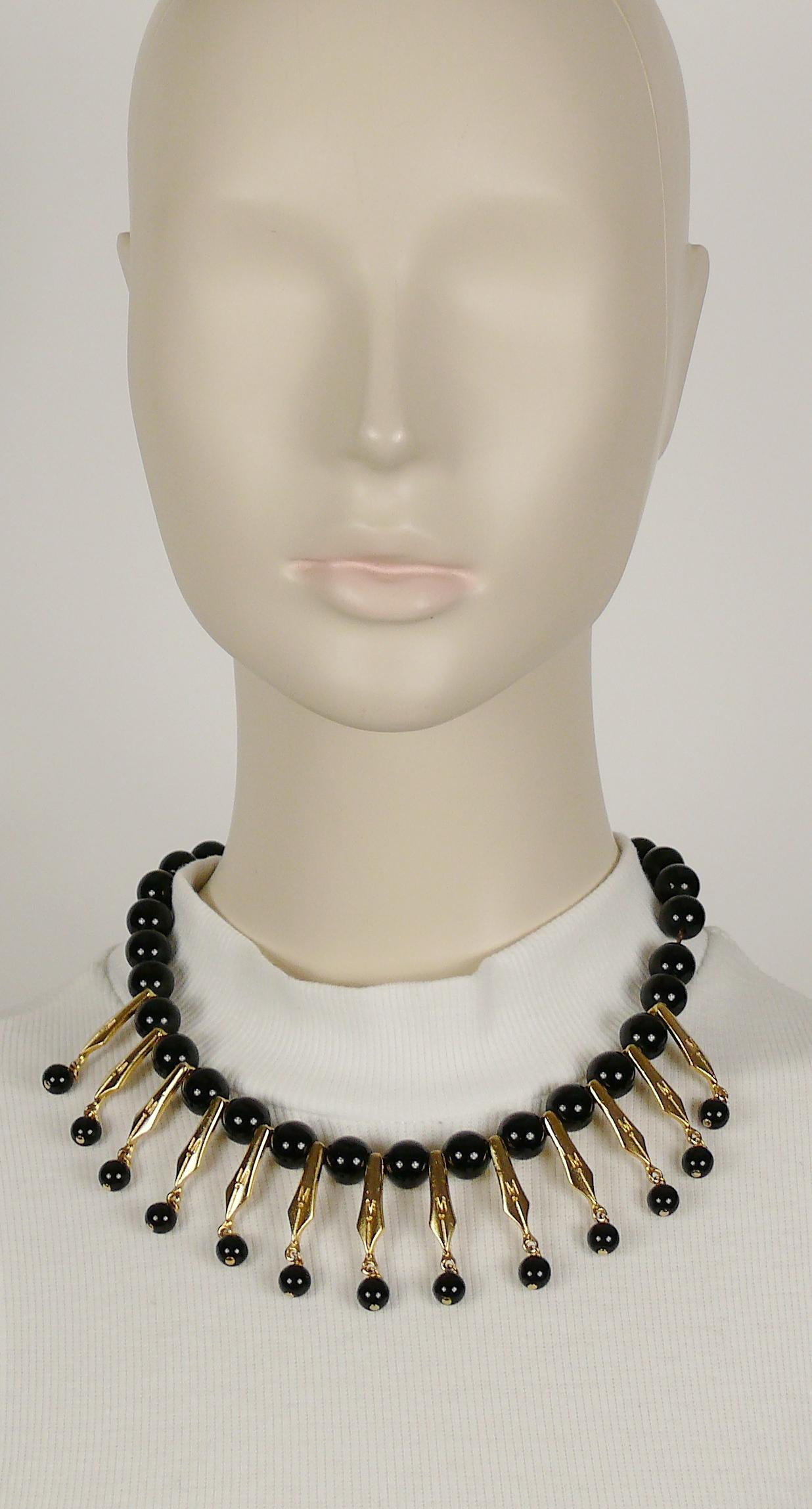 MOSCHINO vintage black resin bead necklace featuring gold toned pen nibs embossed with M initial.

Spring clasp and toggle closure.

Embossed MOSCHINO.

Indicative measurement : length approx. 44 cm (17.32 inches) / drop approx. 3.5 cm (1.38