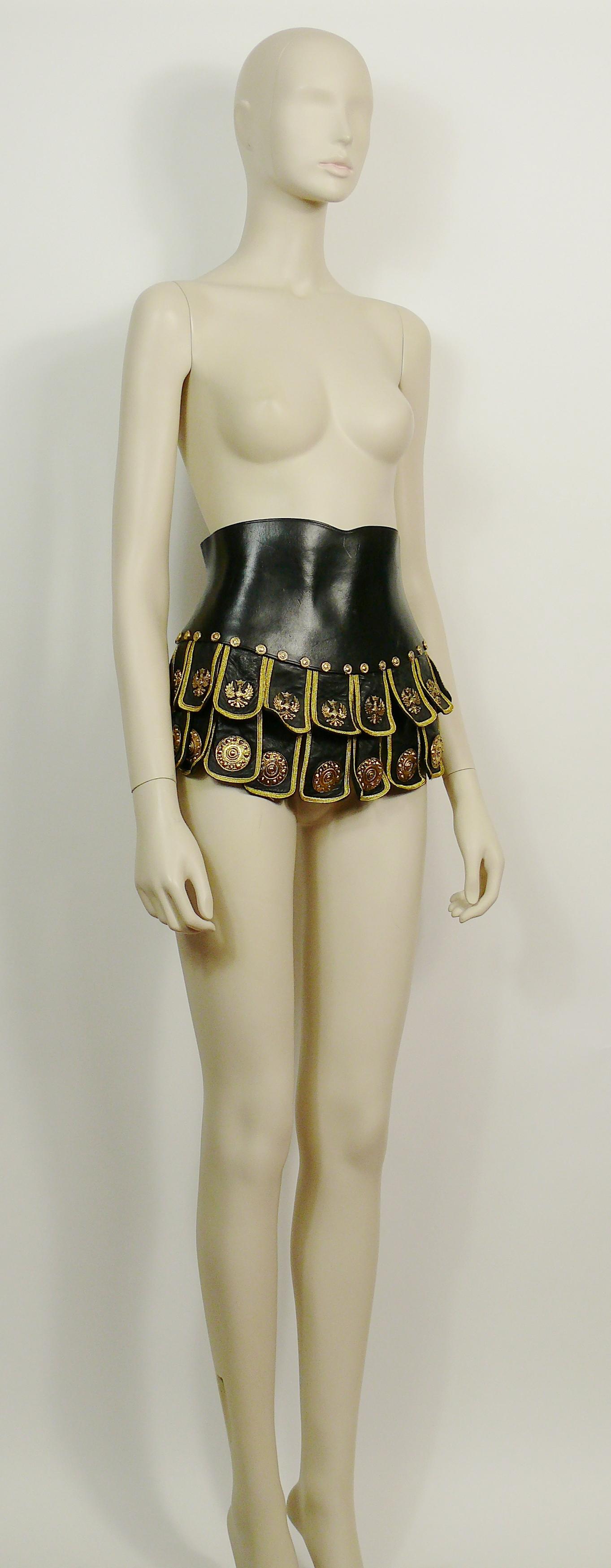 MOSCHINO vintage rare black Roman Centurion soldier corset belt.

This belt features :
- Black leather with gold toned hardware.
- Eagle and shield metal plaques.
- Round embossed studs
- Double layer of scalloped flaps with gold trim.
- Concealed