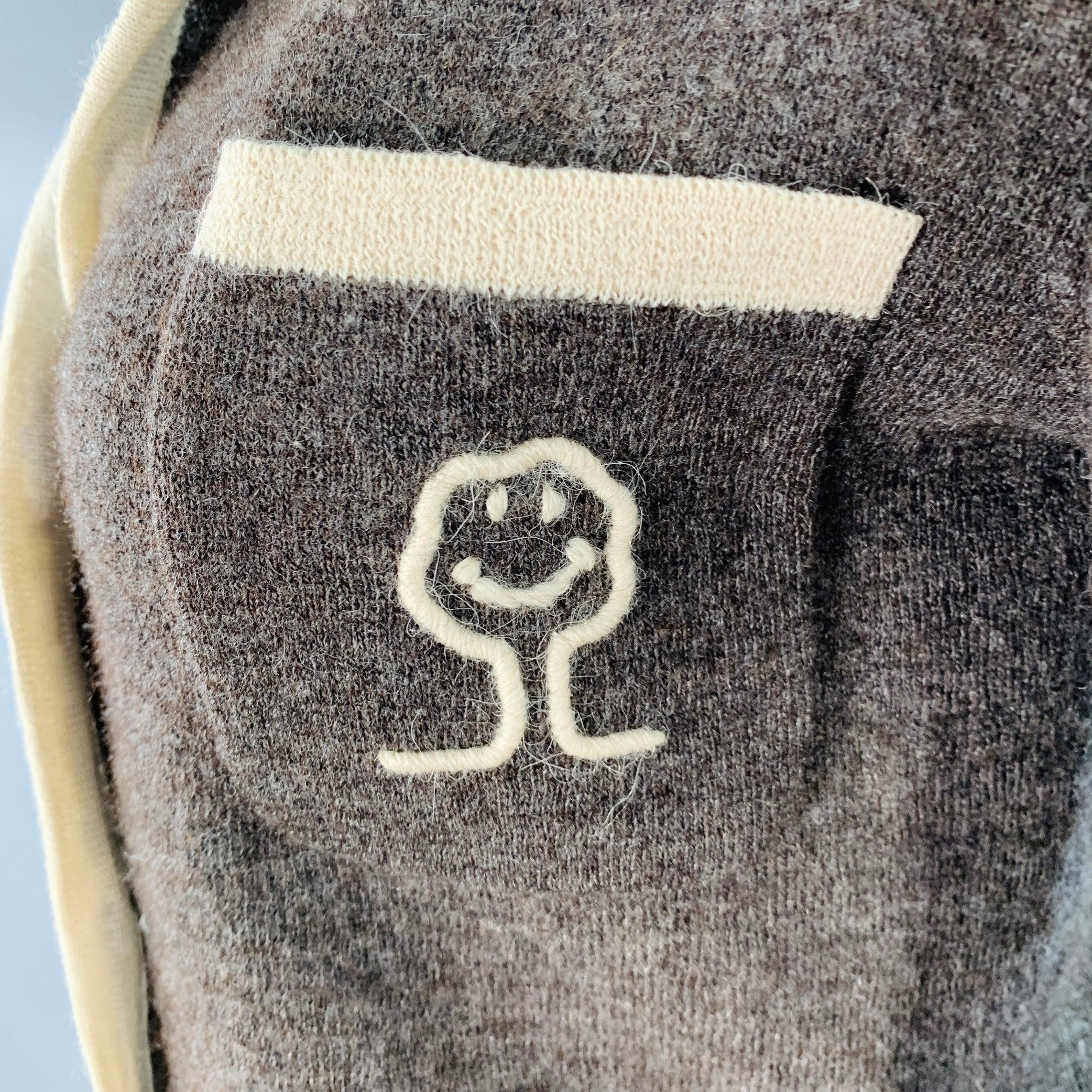 Vintage CHEAP AND CHIC by MOSCHINO cardigan
in a brown wool featuring a cream contrasting trim, three pockets, embroidered tree logo, and button closure.Excellent Pre-Owned Condition.  

Marked:   IT 42 

Measurements: 
 
Shoulder: 16.25 inches