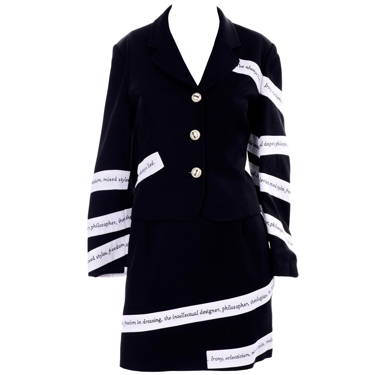 This is a vintage early 1990's Moschino two piece black rayon mini skirt & blazer suit with white ribbon banners embroidered with sayings and words in black: Irony, eclecticism, mixed styles, freedom in dressing, the intellectual designer,