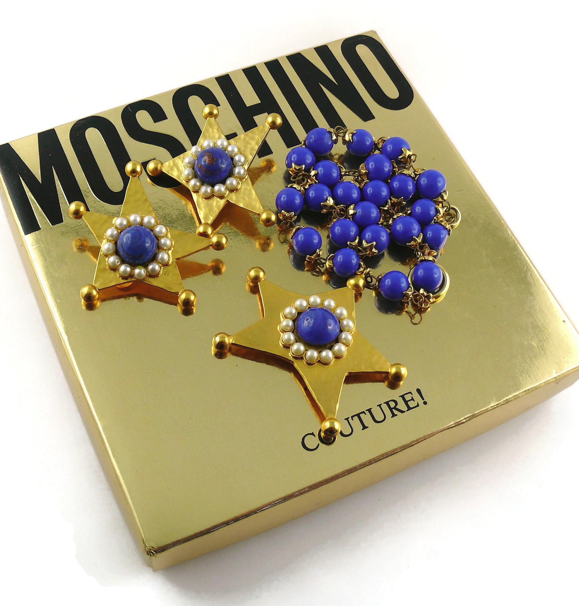 MOSCHINO vintage gold toned textured star necklace and clip-on earrings set embellished with marbled blue glass cabochons/beads and faux pearls.

NECKLACE
Spring clasp and toggle closure.
Indicative measurements : length approx. 46 cm (18.11 inches)