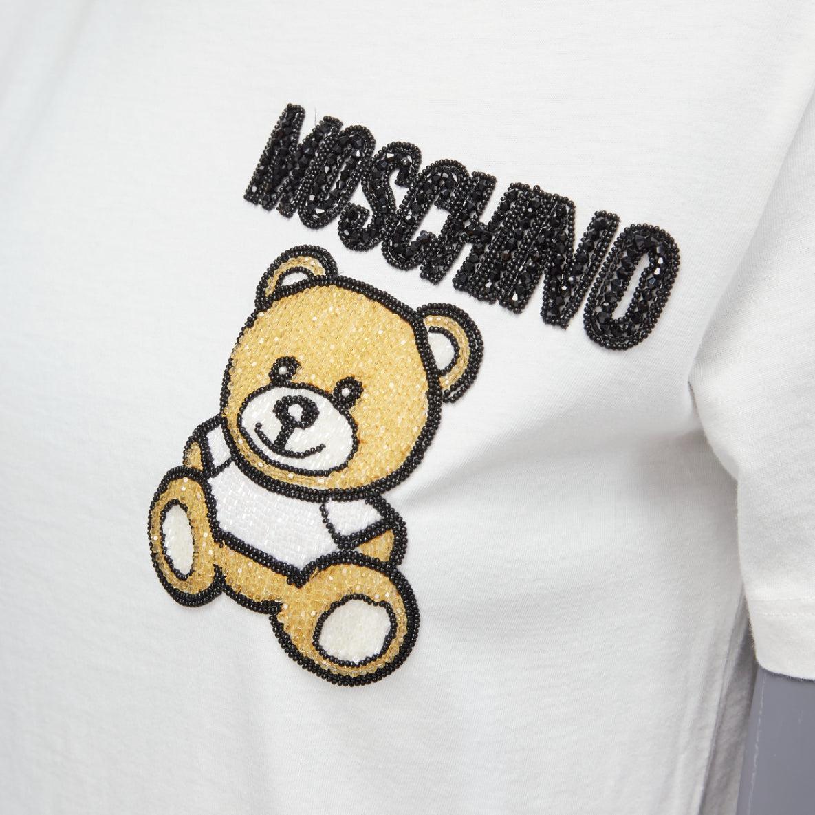 MOSCHINO white black brown beaded embroidery bear short sleeve tshirt IT38 XS
Reference: KYCG/A00055
Brand: Moschino
Material: Cotton
Color: White, Black
Pattern: Logomania
Closure: Pullover
Extra Details: Beaded teddy at right chest.
Made in: