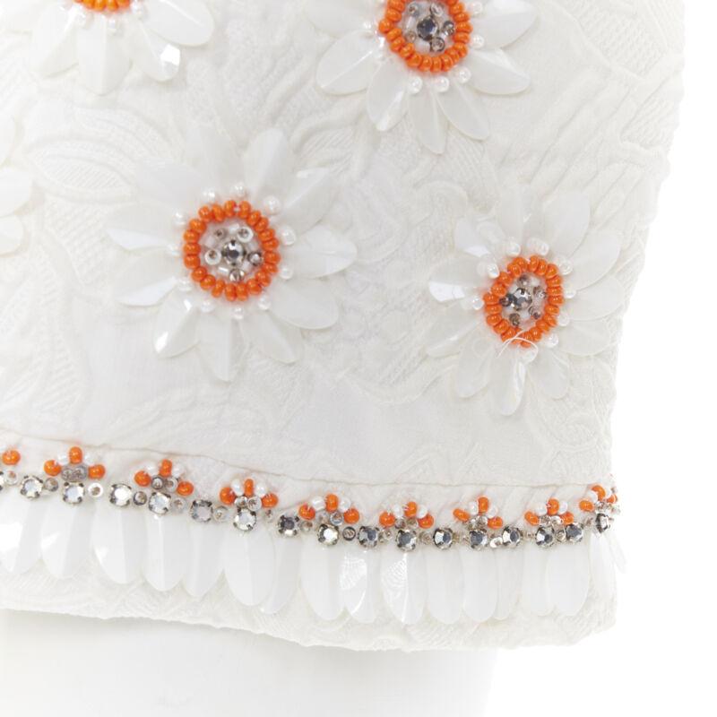 MOSCHINO white cloque cotton orange bead crystal floral embellished top IT38 
Reference: LNKO/A01249 
Brand: Moschino 
Designer: Jeremy Scott 
Material: Cotton 
Color: White 
Pattern: Floral 
Closure: Zip 
Extra Detail: Cap sleeves. 3D plastic and