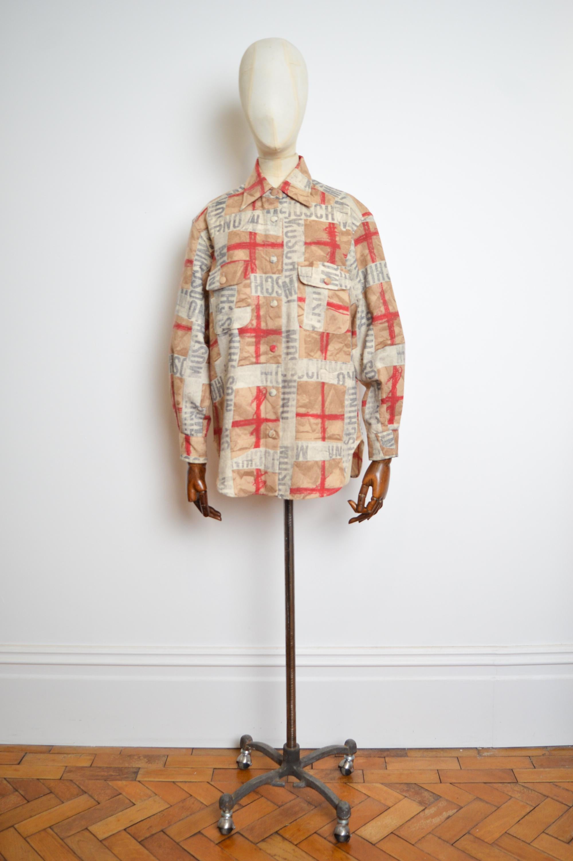 Moschino Wool early 1990's button down long sleeve spell out Shirt / Shaket. 
Imprimé d'archives Moschino dans les tons beige, gris et rouge, avec logo répété sur l'ensemble de la pièce.
Boutons sur le devant 
Poches de poitrine 
FABRIQUÉ AUX