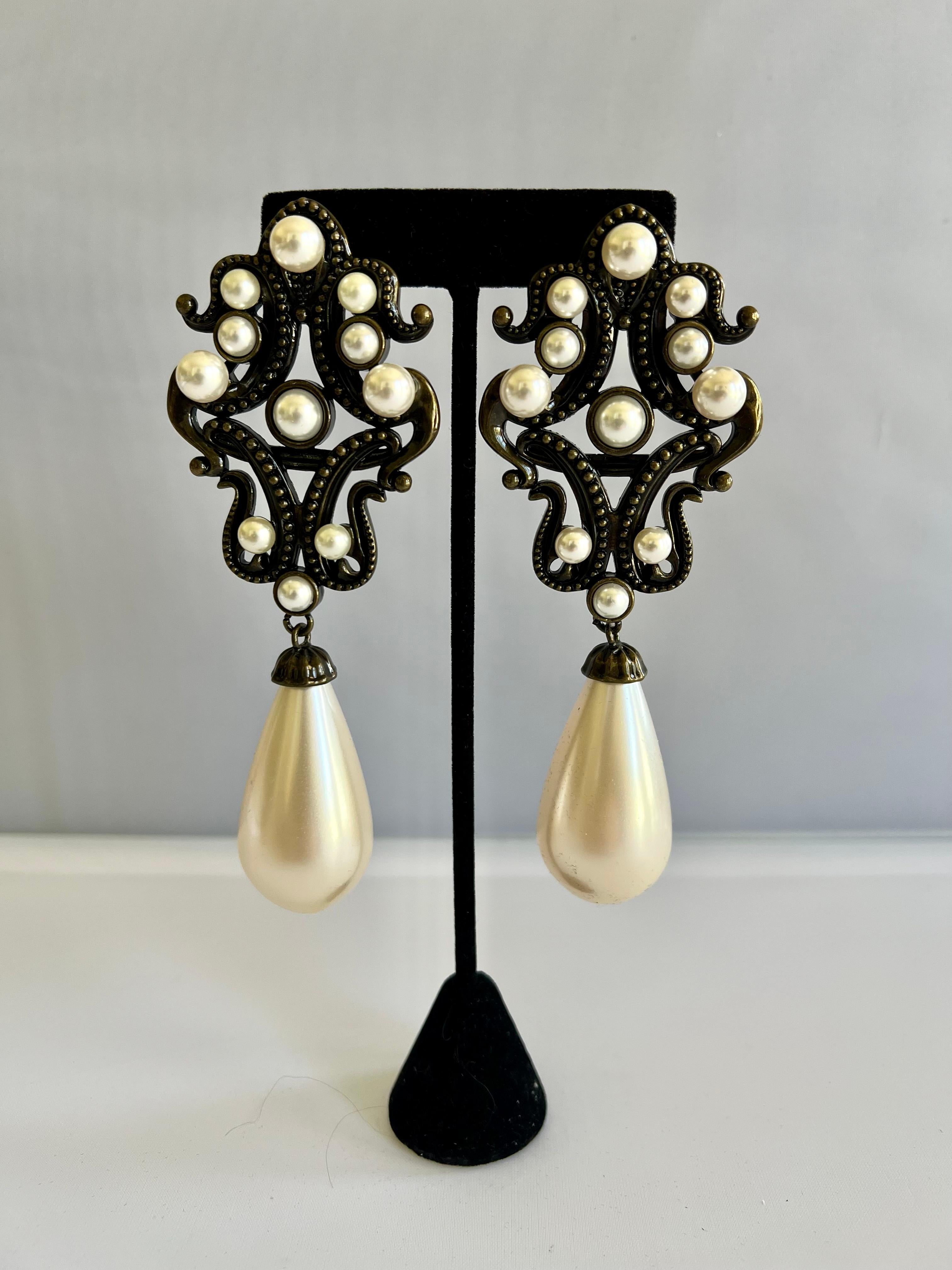 Exaggerated silver-tone clip-on earrings with teardrop pearl pendants and brass elements from Moschino.