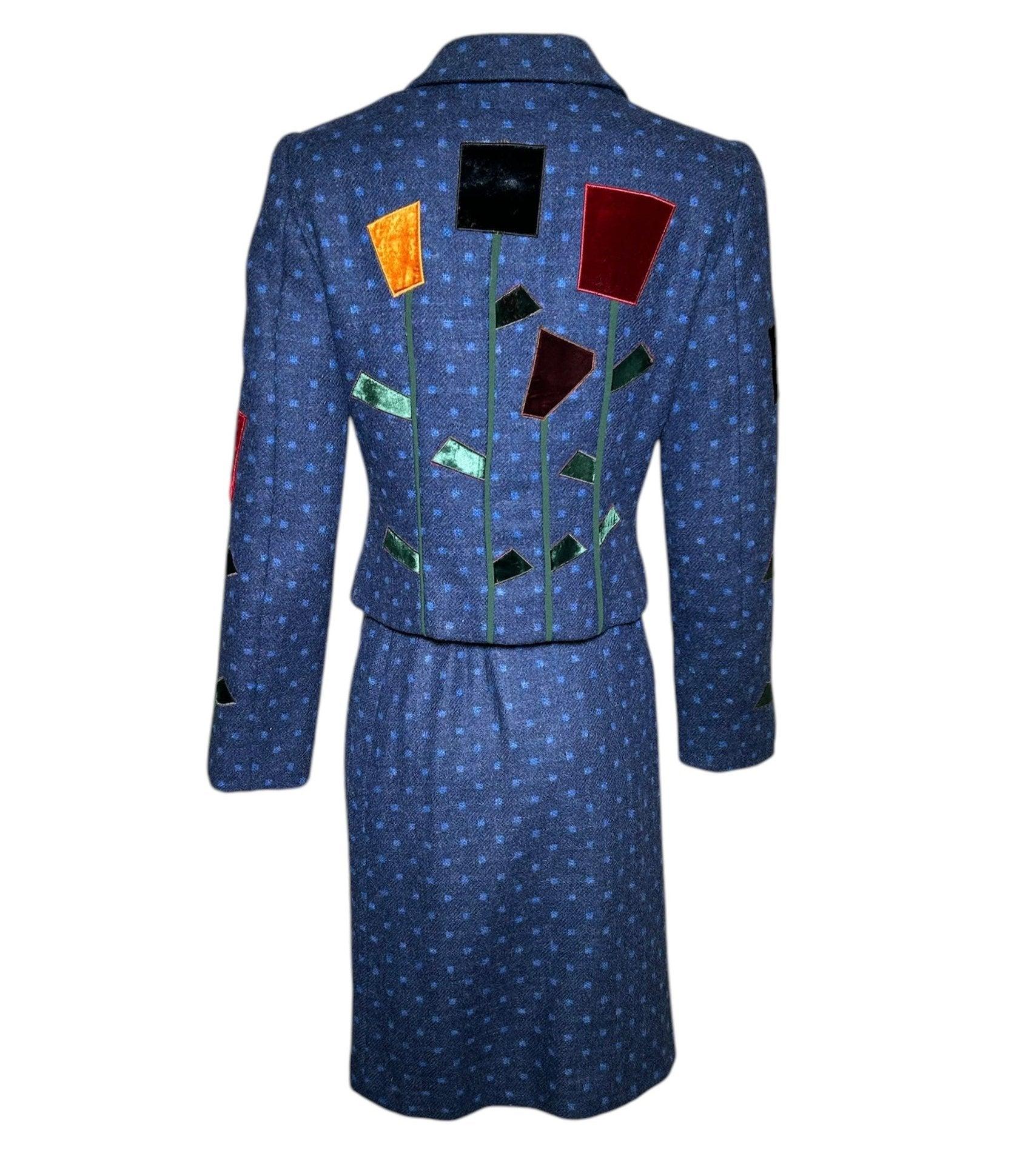 This adorable wool suit ensemble is from Moschino's Cheap and Chic line and embodies all the line's lovable quirkiness.  The real centerpiece of this suit is the abstract geometric velvet flowers and leaves that scatter throughout the suit jacket.