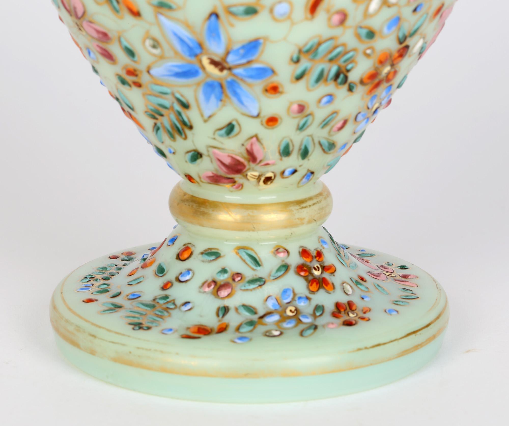 A stunning green opalescent hand blown glass vase exquisitely decorated in colored enamels with a snake amidst floral and leaf designs attributed to Moser and dating from the latter 19th century. This finely made vase stands on a rounded pedestal