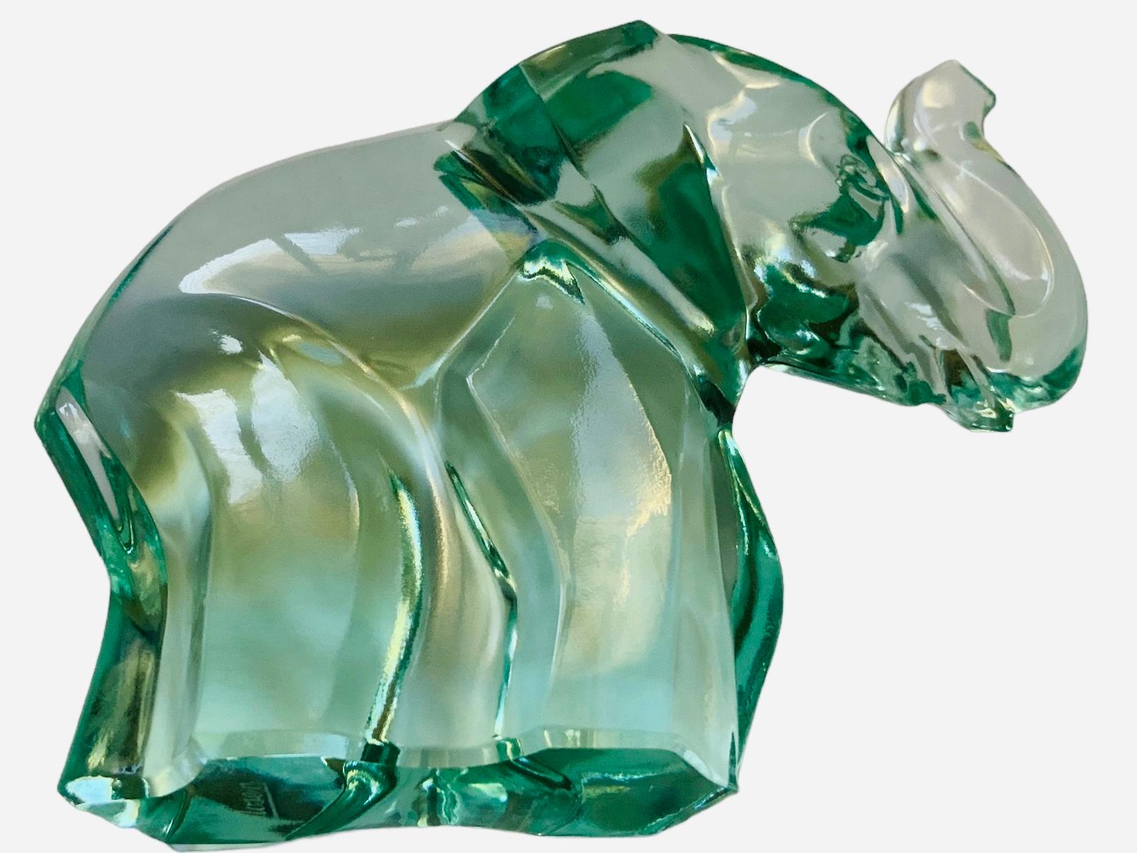 This is a Moser light green crystal sculpture of a happy elephant with a large trunk up. Below the base is signed Moser. Elephants are symbol of good luck, wisdom and prudence.