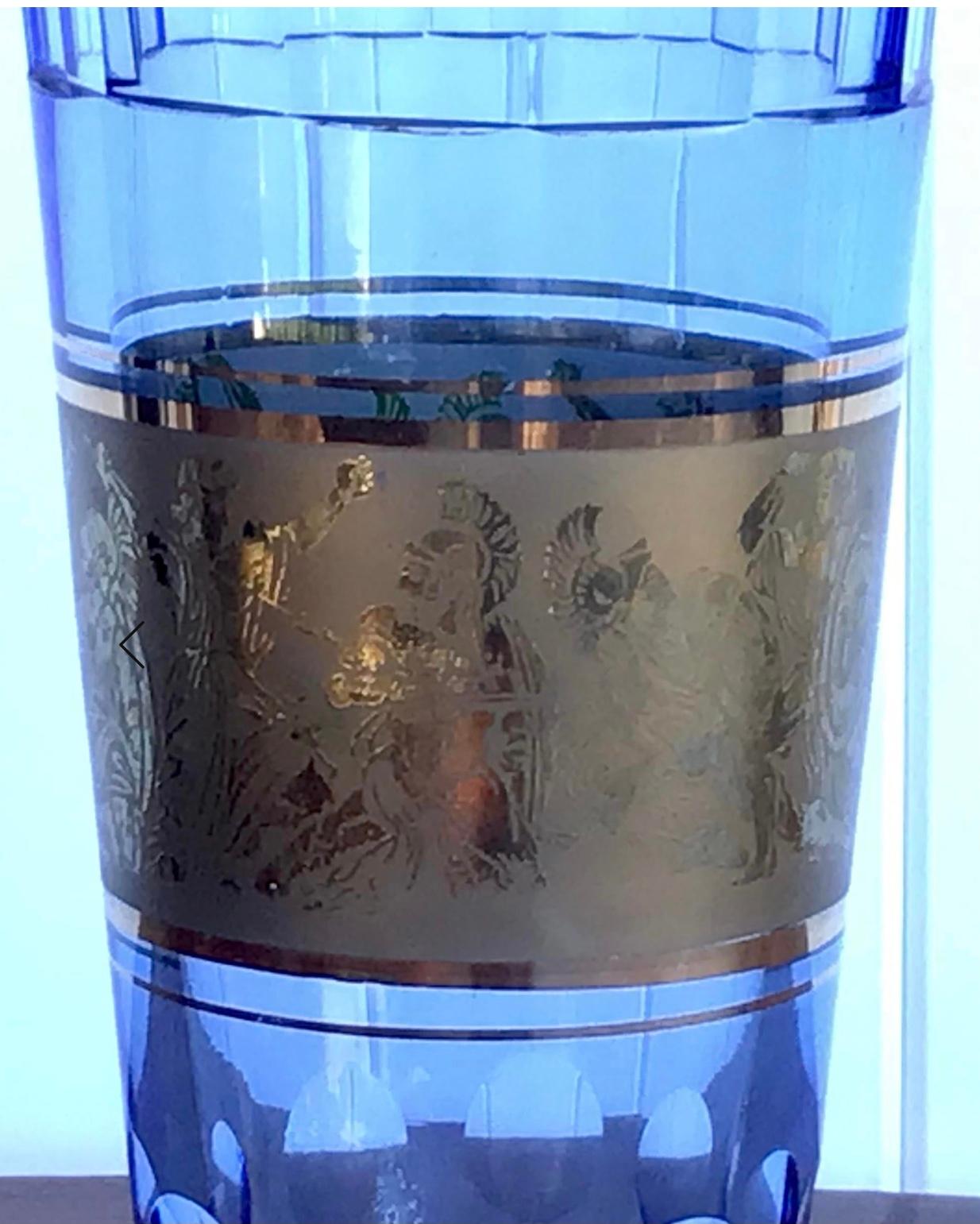 Moser Glass (Czechoslovakia) design of a blue crystal colored vase that features classical warriors in gold relief. This piece doesn't have a label or a signature, but may have been one of Josef Hoffmann's designs created in the 1920s. It is heavy